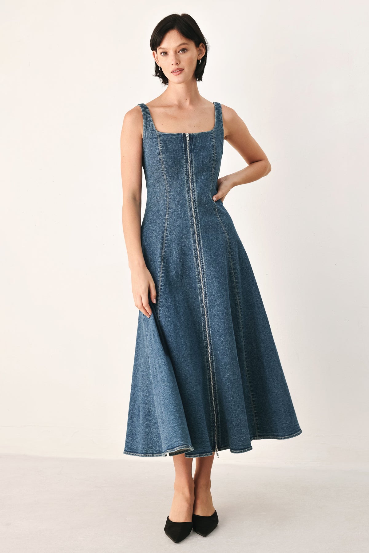 A woman modeling a sleeveless blue denim midi dress with a front zipper, square neckline, and flared skirt | FREEMARKET