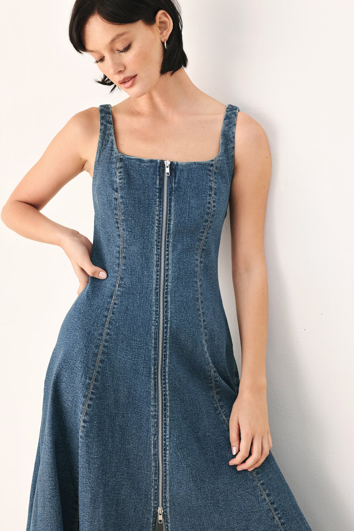 A woman modeling a sleeveless blue denim midi dress with a front zipper, square neckline, and flared skirt | FREEMARKET