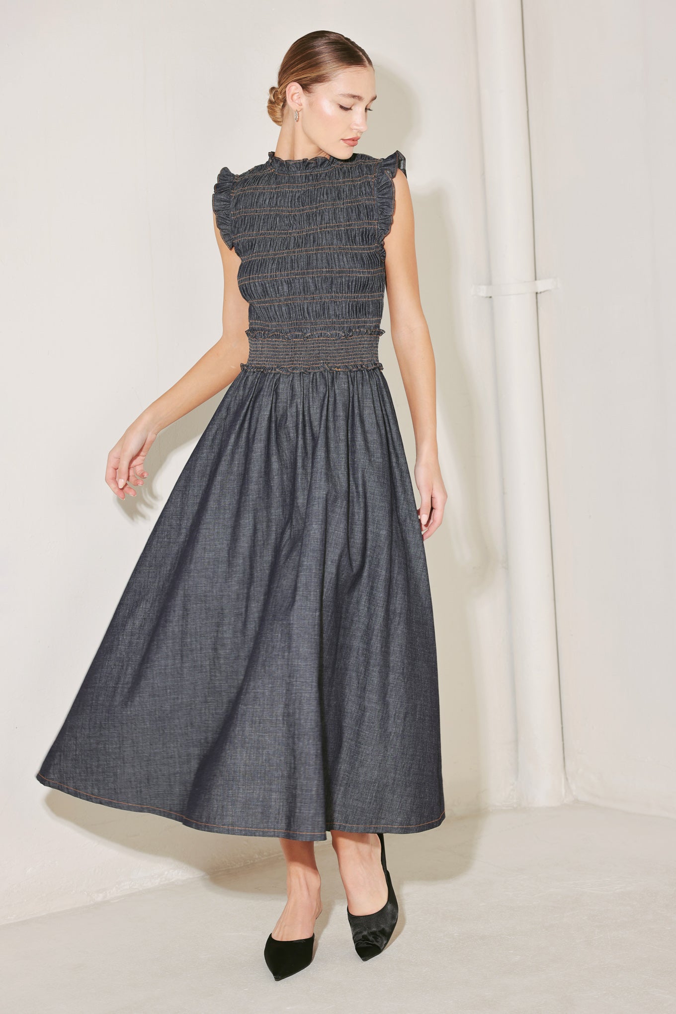 A denim midi dress featuring ruffle neckline, ruffle sleeve, smocked bodice and waist band, full skirt and back neck button closure
Details:
Self : 95% Cotton 5% Polyester
Size & Fit
- Model is 5`8" And Wearing Size Small
- Measurements Taken From Size Small
- Approx. Length: 52"