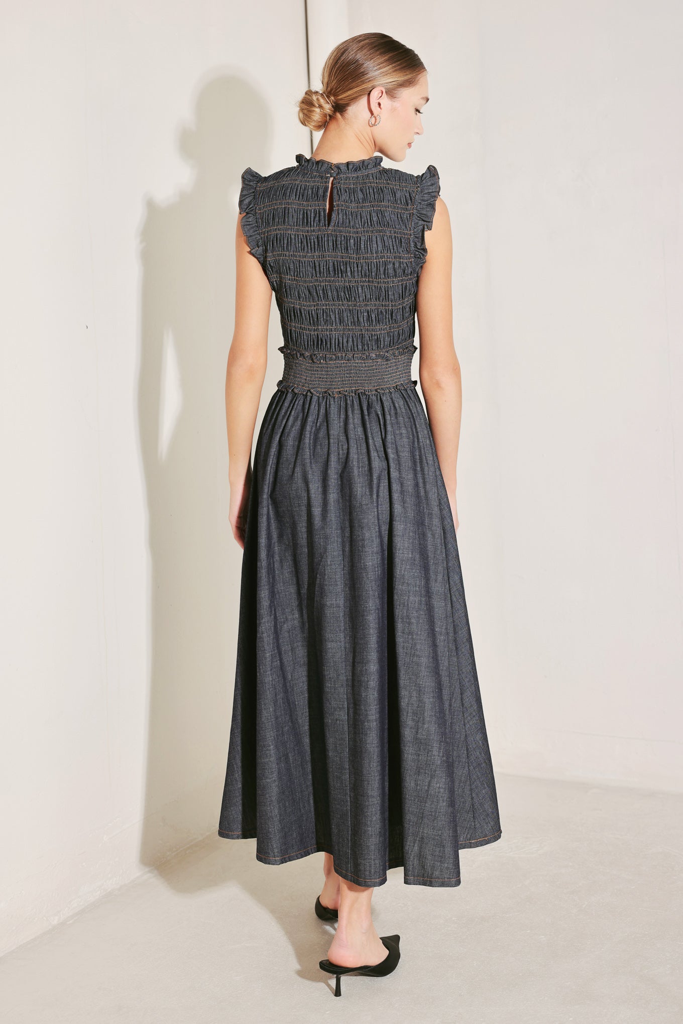 A denim midi dress featuring ruffle neckline, ruffle sleeve, smocked bodice and waist band, full skirt and back neck button closure
Details:
Self : 95% Cotton 5% Polyester
Size & Fit
- Model is 5`8" And Wearing Size Small
- Measurements Taken From Size Small
- Approx. Length: 52"