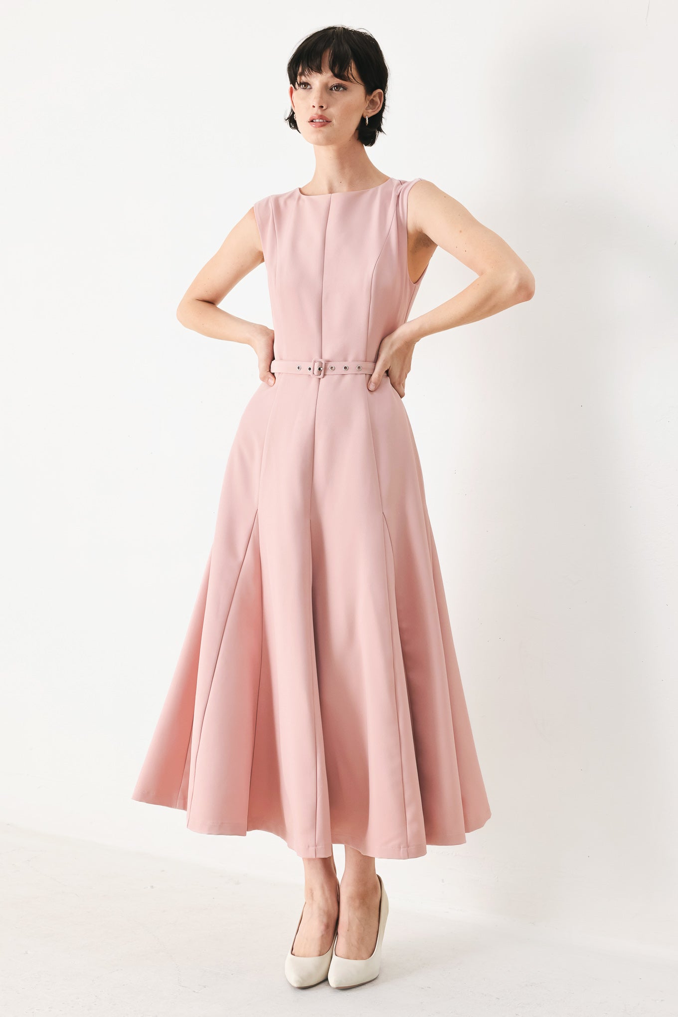 Woman wearing a pink midi dress featuring round neckline, sleeveless, self belt, full circle skirt and back zipper closure | FREEMARKET