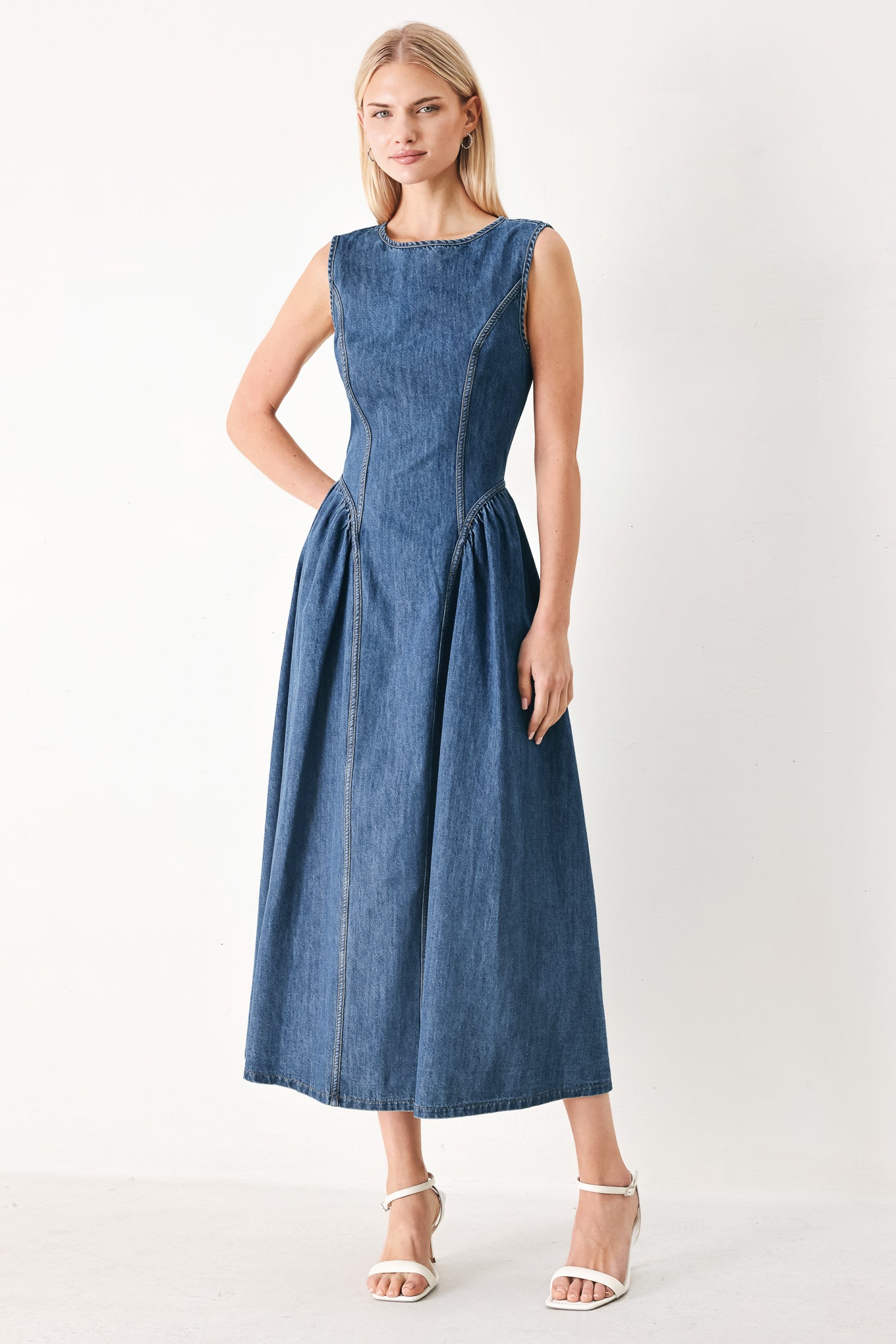 Woman wearing a blue denim midi dress featuring round neckline, sleeveless, side shirred full skirt and back zipper closure | FREEMARKET