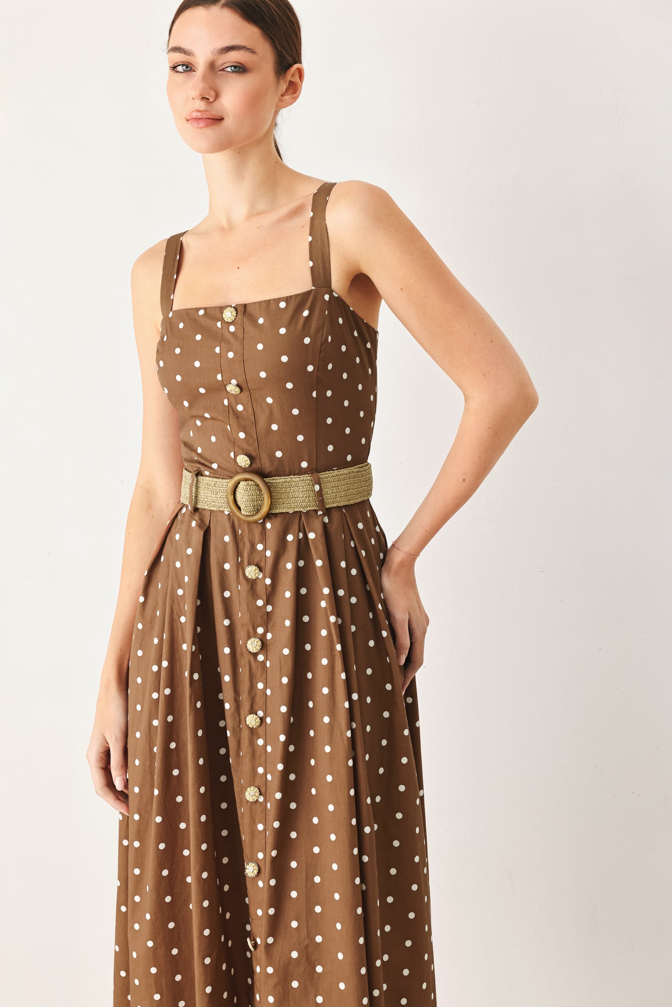 Woman wearing a brown with white polka dot midi dress featuring straight neckline, straps, button down detail, contrasting belt, full skirt and back zipper closure | FREEMARKET