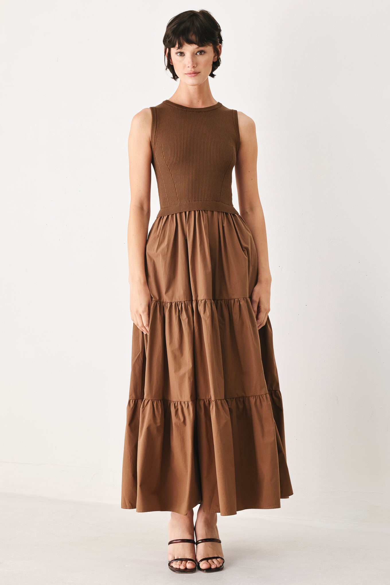 Woman wearing a brown sleeveless sweater knit and woven mix midi dress featuring round neckline and tier skirt | FREEMARKET