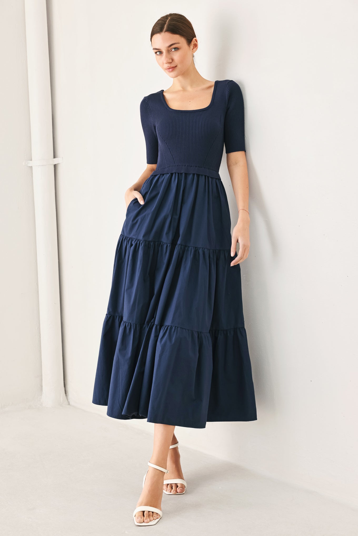 Woman wearing a solid sweater knit and woven mix navy blue midi dress featuring square neckline, short sleeve and tier skirt | FREEMARKET