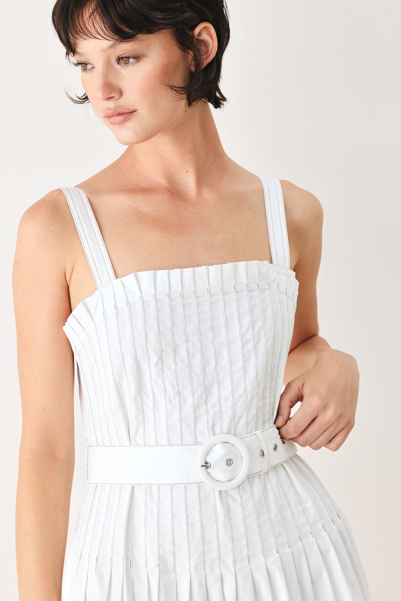 Woman wearing a white midi dress featuring straight neckline, straps, pintuck bodice, self belt and side zipper closure | FREEMARKET