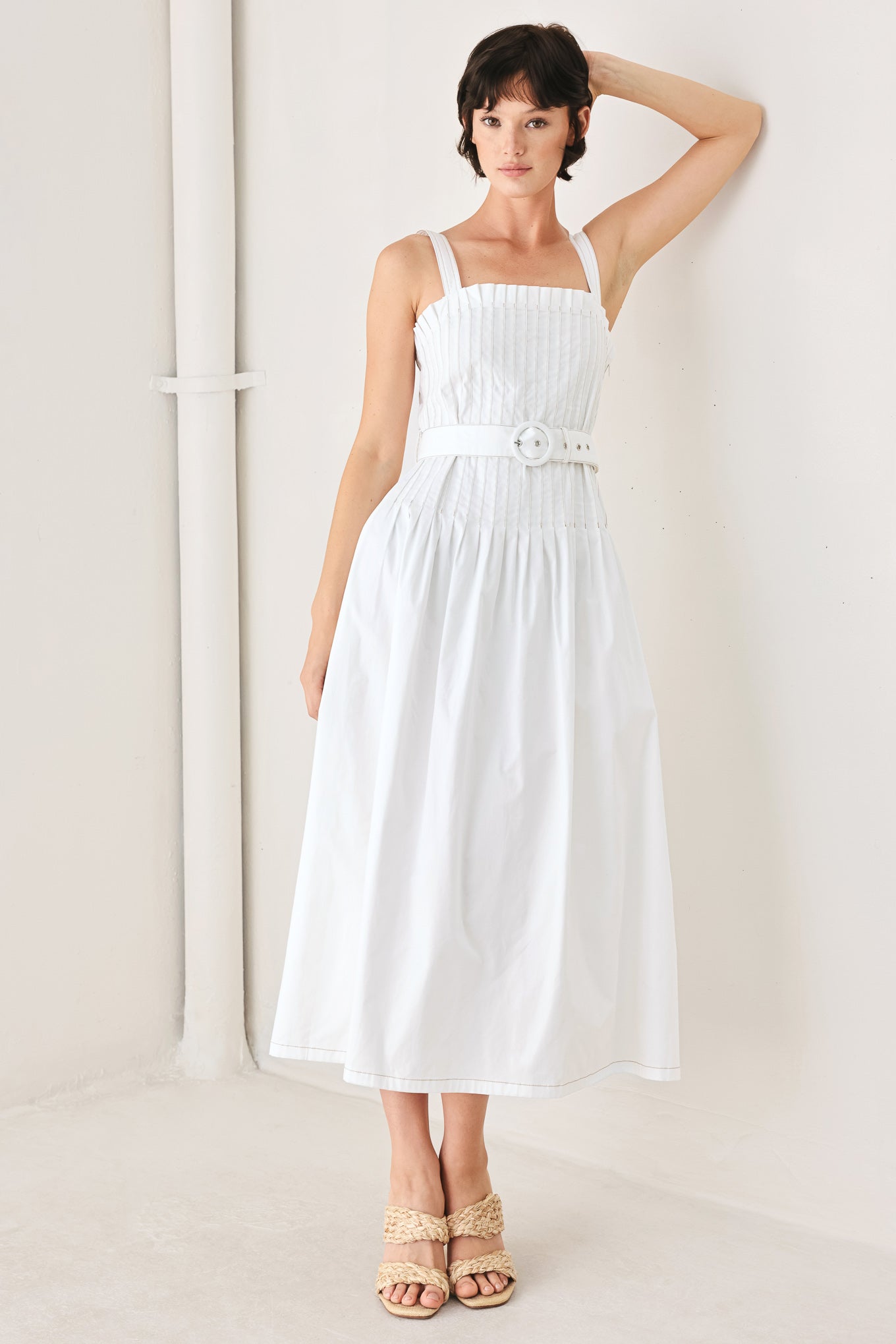 Woman wearing a white midi dress featuring straight neckline, straps, pintuck bodice, self belt and side zipper closure | FREEMARKET