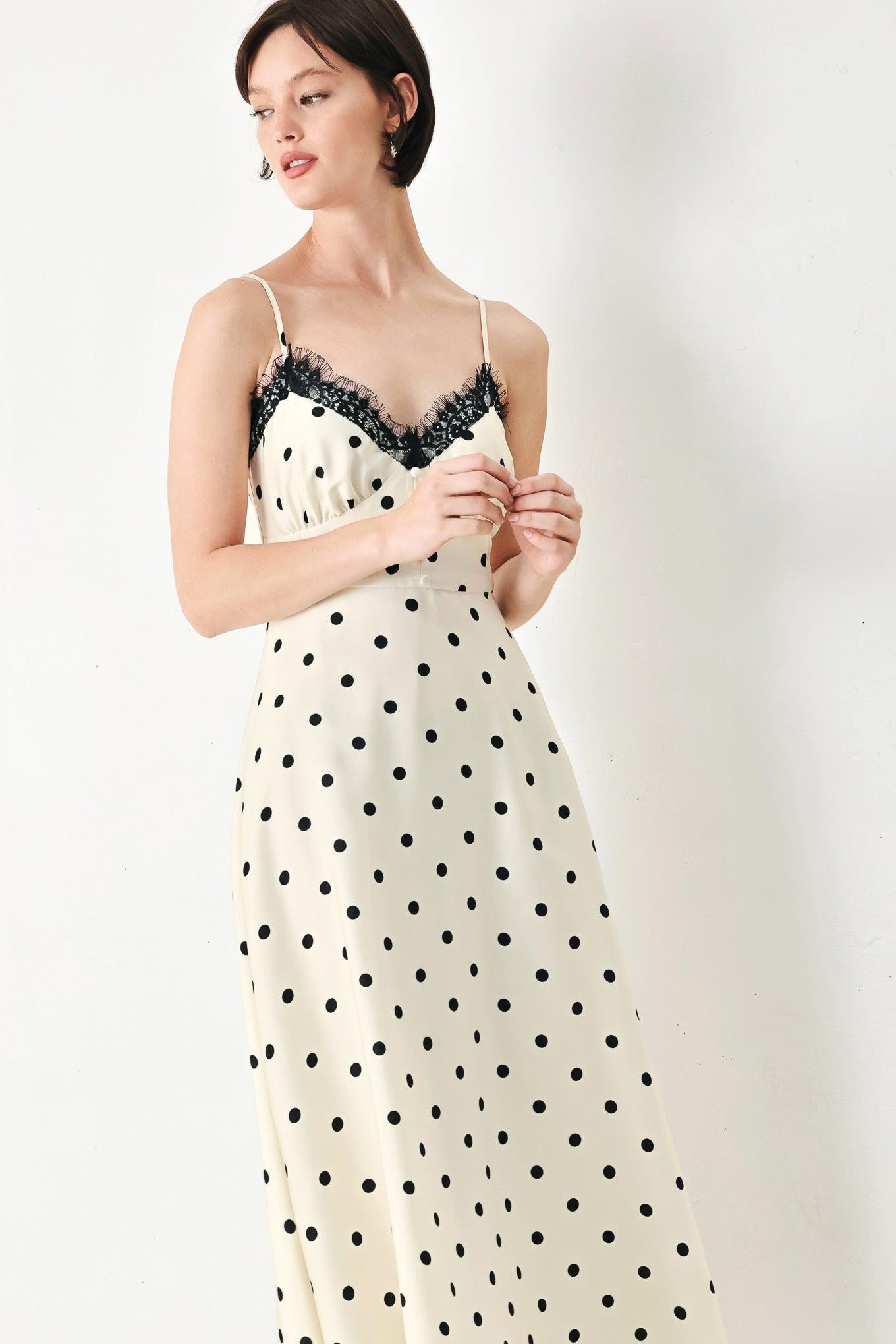 A printed woven midi dress featuring cami top with lace trim, straps, waist yoke with buttons, circle skirt and back zipper closure