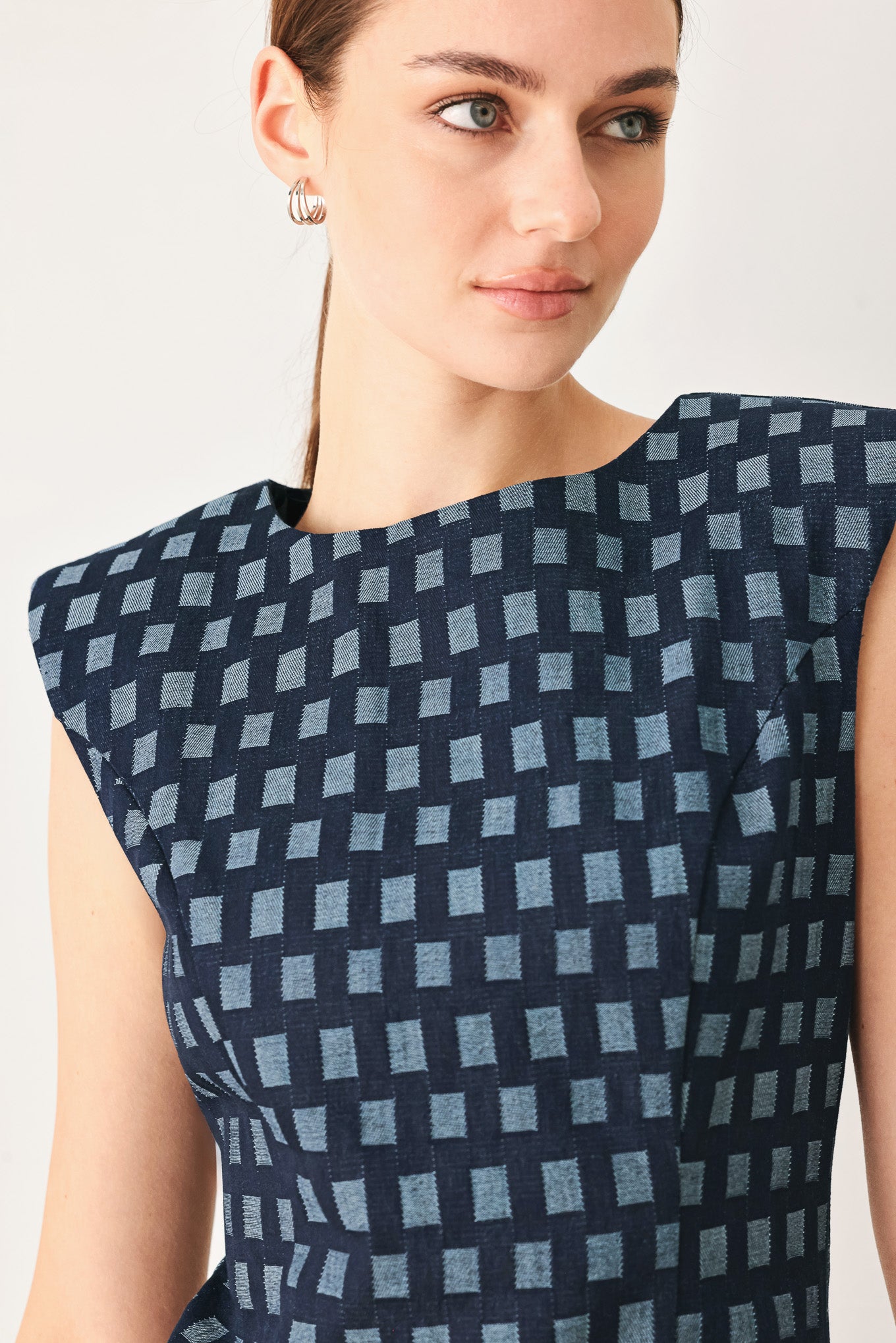 Woman wearing a denim navy patterned jacquard denim mini dress with round neckline, sleeveless and back zipper closure | Flying Tomato