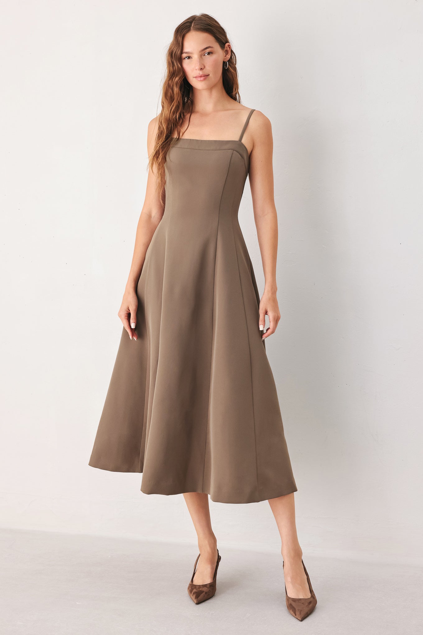 A woman wearing a sleeveless midi dress in a muted mocha-brown color | FREEMARKET
