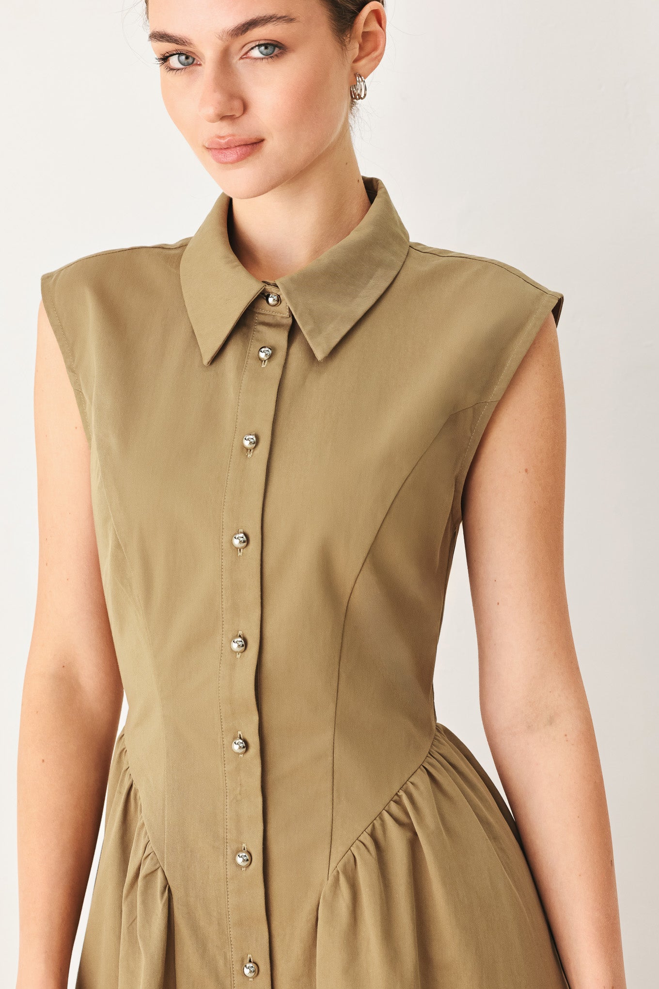 Woman wearing a sleeveless mocha woven midi dress featuring collar, button down and side shirred skirt | FREEMARKET