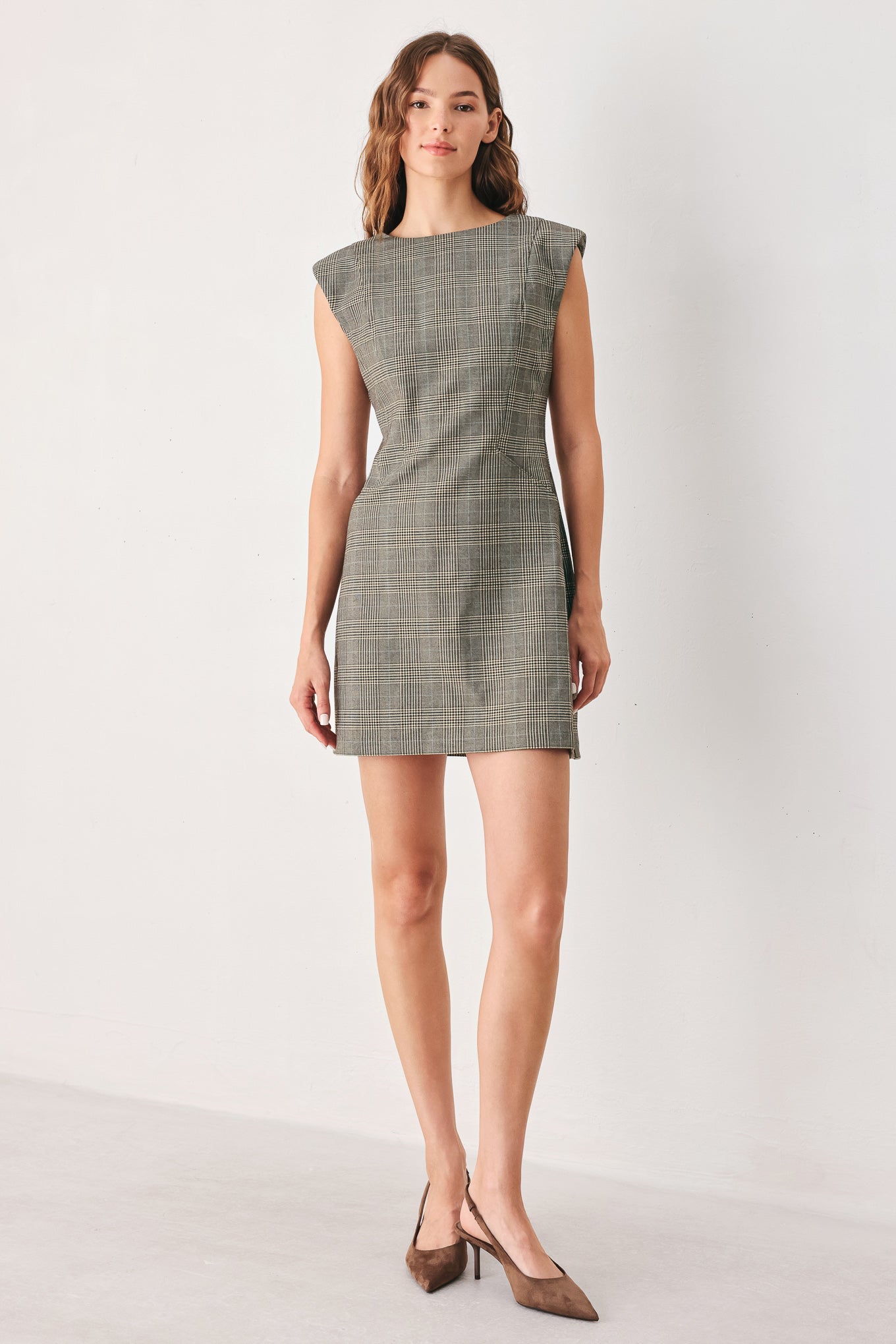 A woman wearing a sleeveless, min gray plaid dress with structured shoulders | FREEMARKET