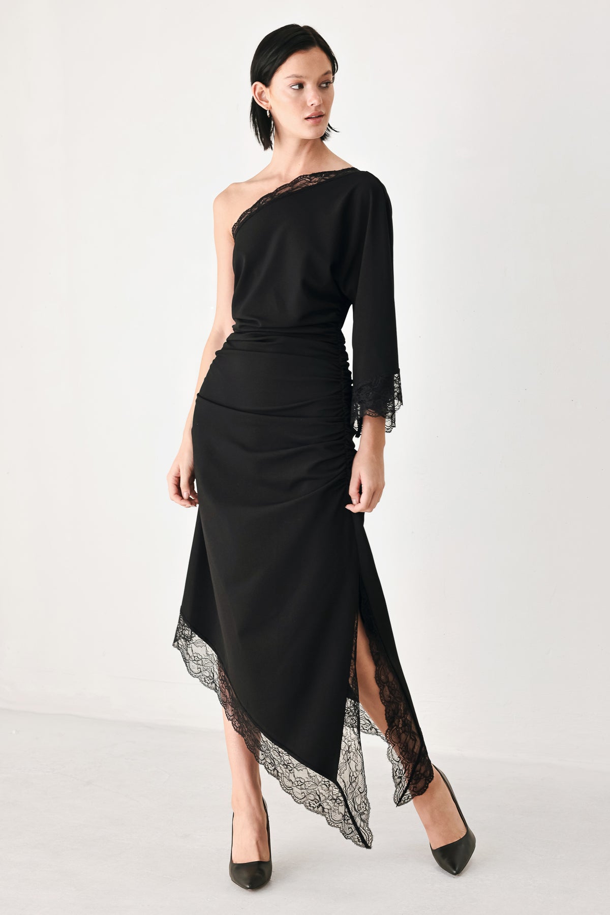 A model wearing a black one-shoulder midi dress with lace trim on the sleeve and hem | FREEMARKET