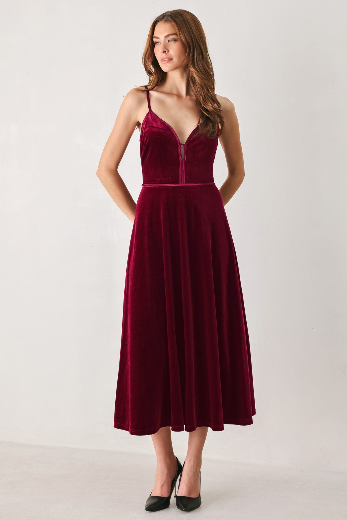 Woman wearing a sleeveless red burgundy velvet midi dress with a slight plunge | FREEMARKET