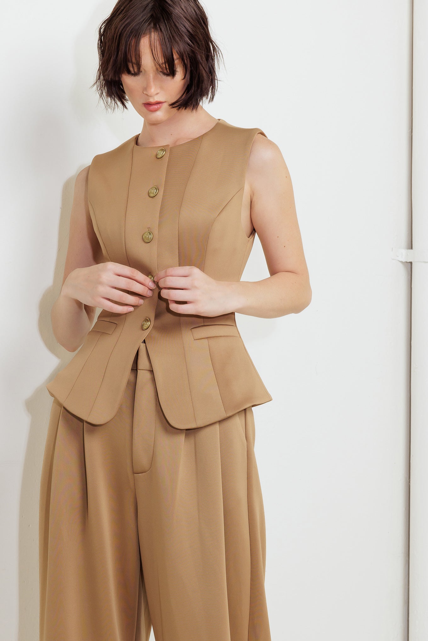 A solid woven vest featuring round neckline, sleeveless, front button down and pockets.