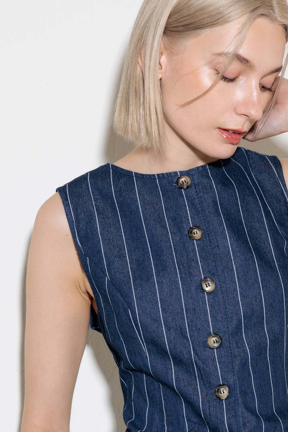 A striped woven vest featuring round neckline, sleeveless and button down.