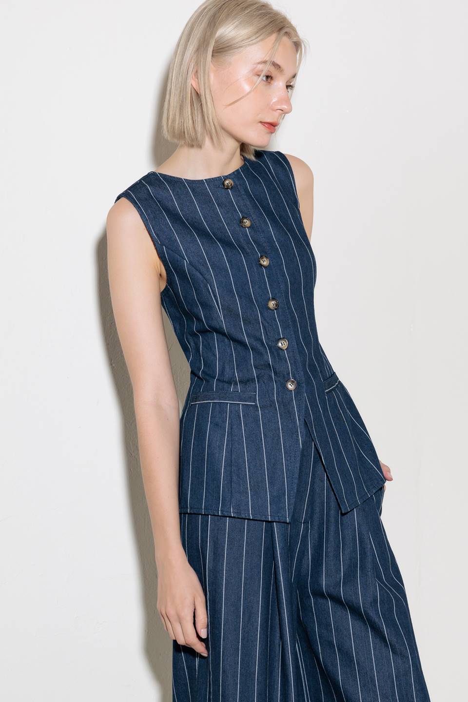 A striped woven vest featuring round neckline, sleeveless and button down.