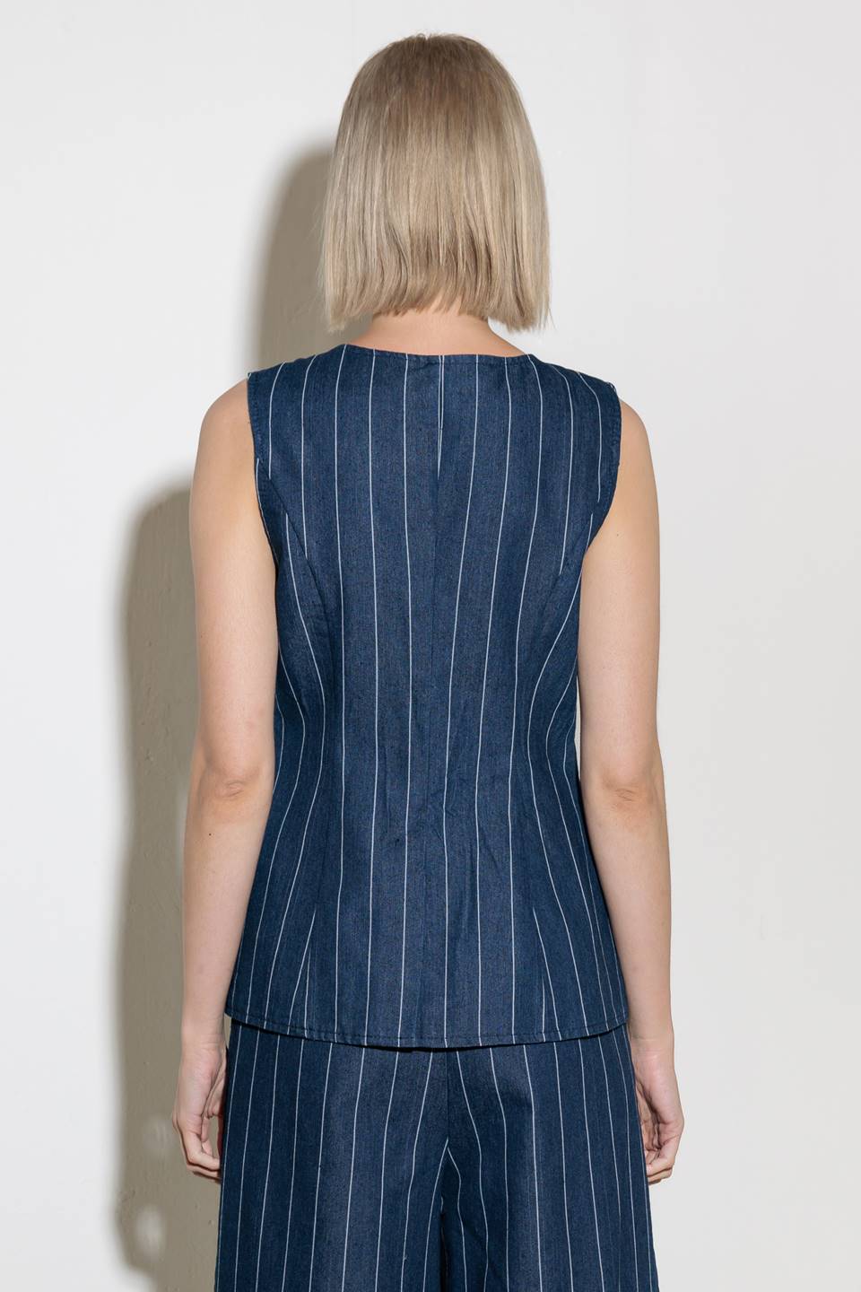 A striped woven vest featuring round neckline, sleeveless and button down.