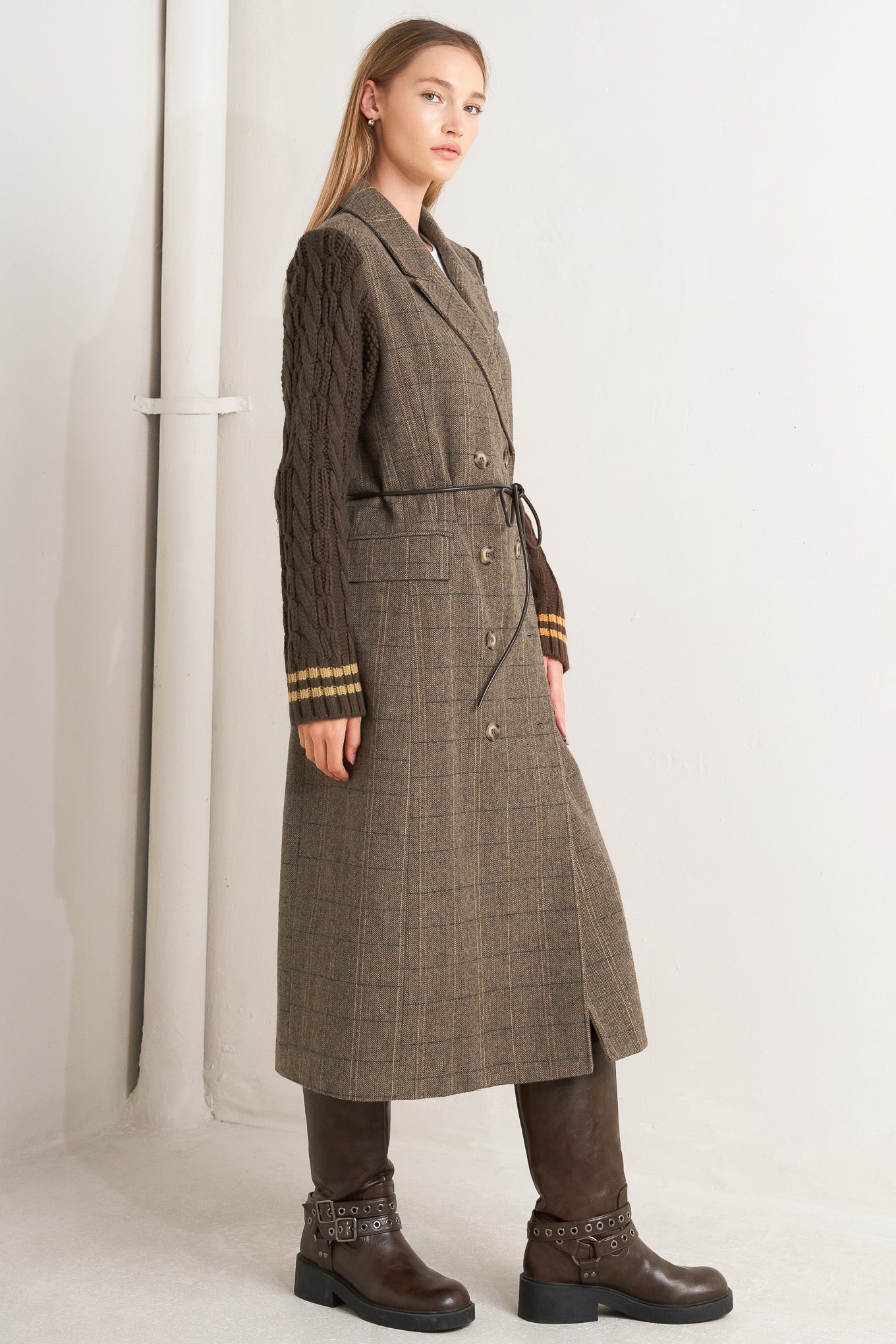 A woven midi coat featuring double breast front button closure, contrasting belt and sweater sleeve