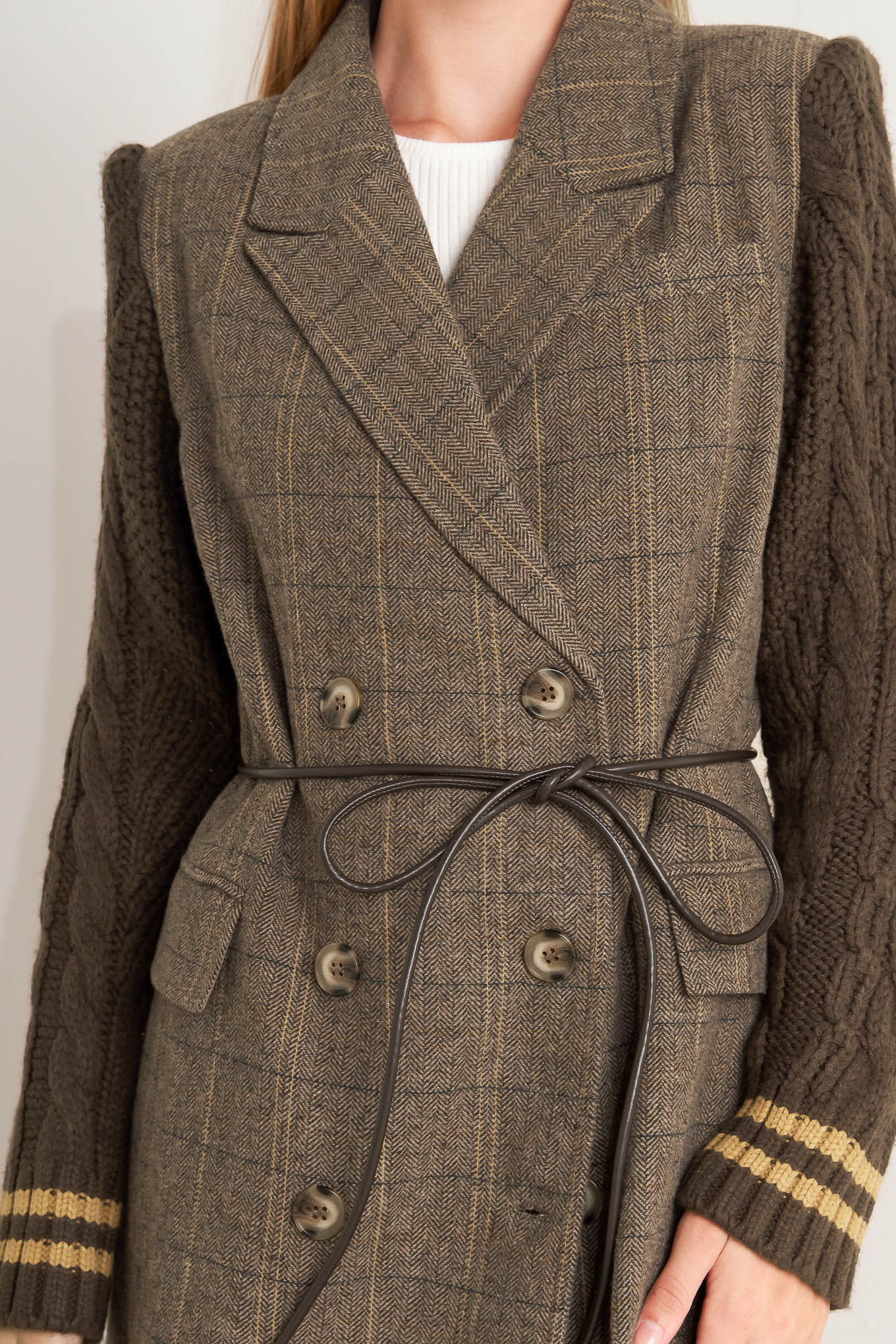 A woven midi coat featuring double breast front button closure, contrasting belt and sweater sleeve