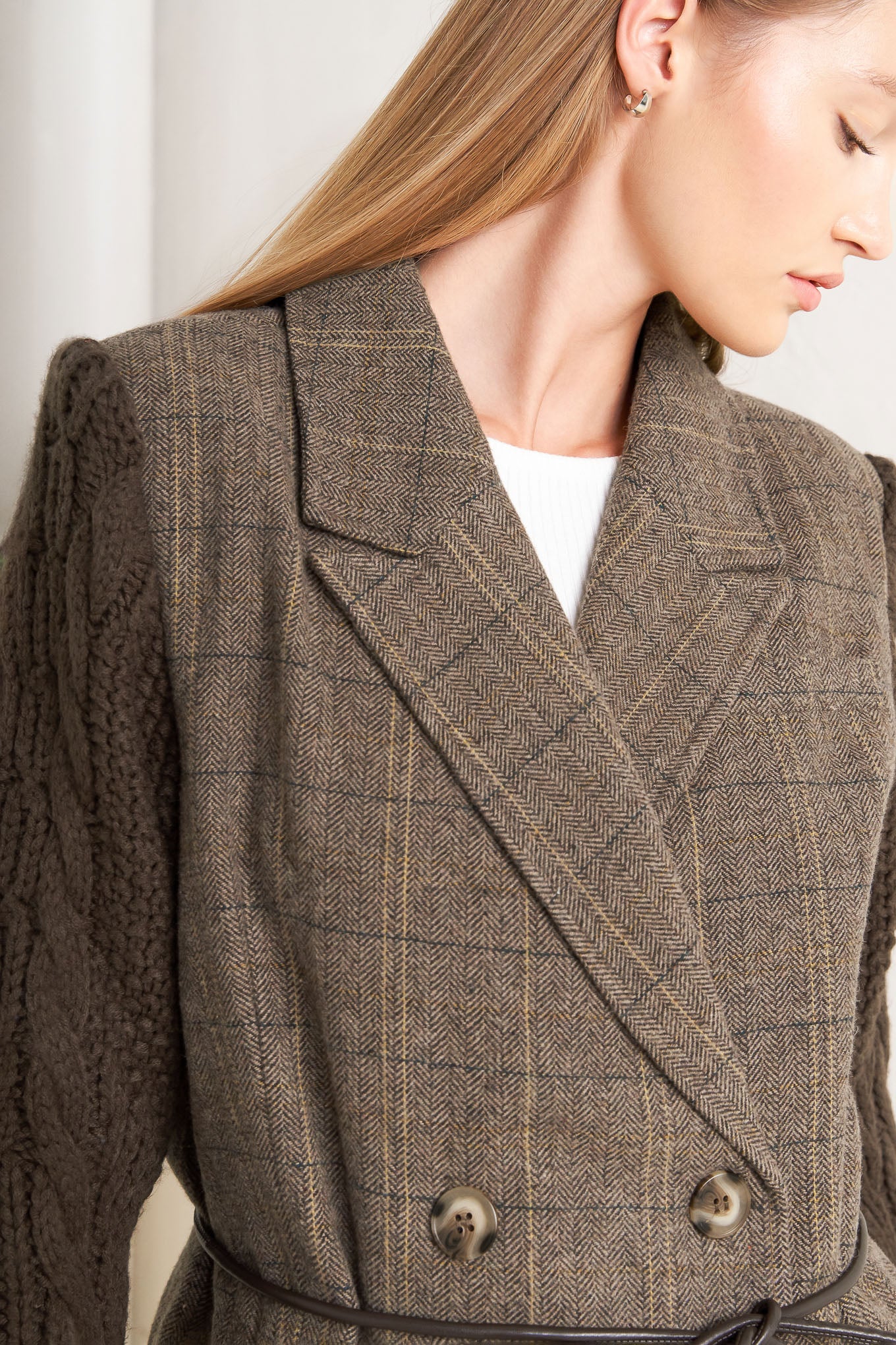 A woven midi coat featuring double breast front button closure, contrasting belt and sweater sleeve