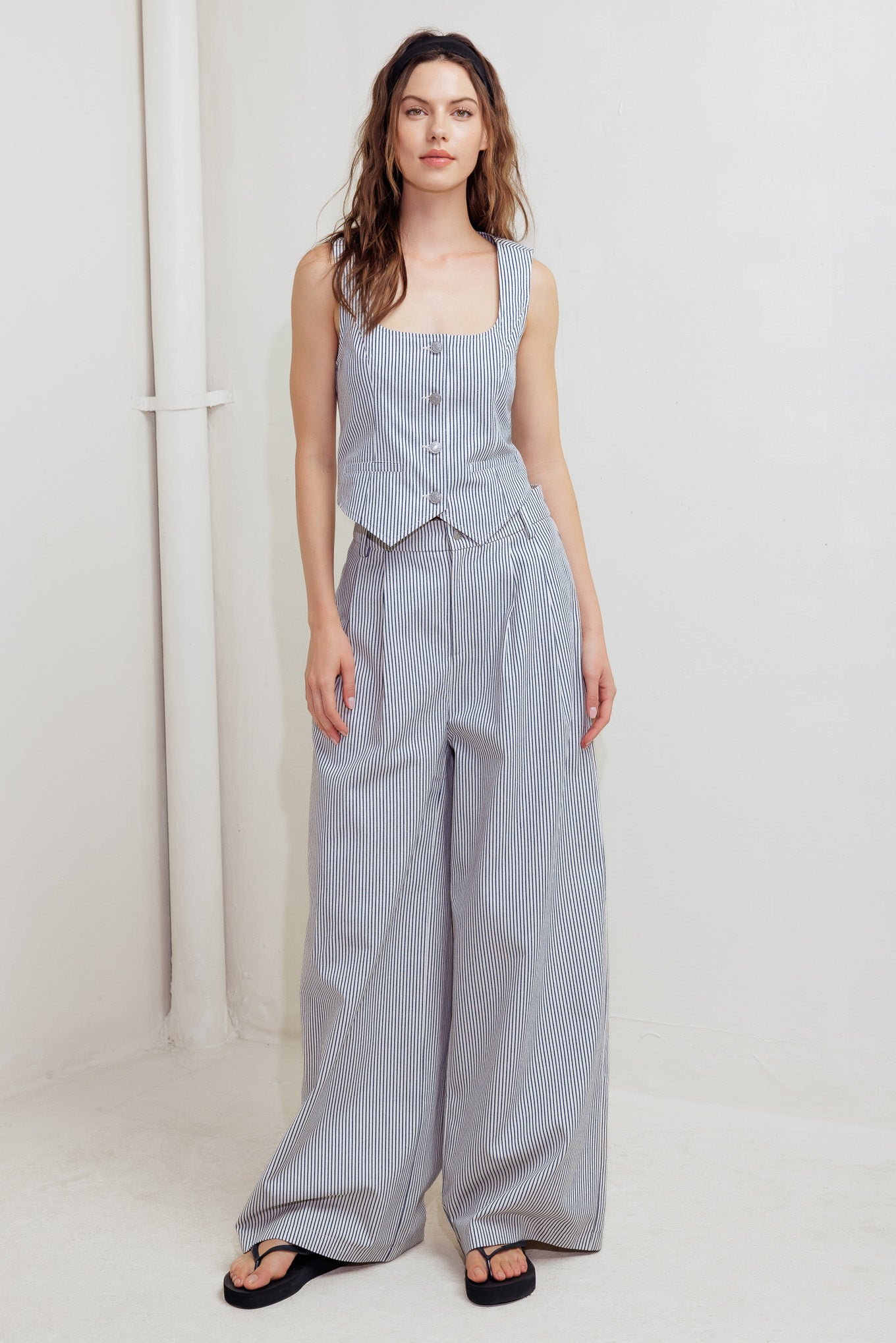 A striped woven vest featuring U neckline, sleeveless and front button down.
