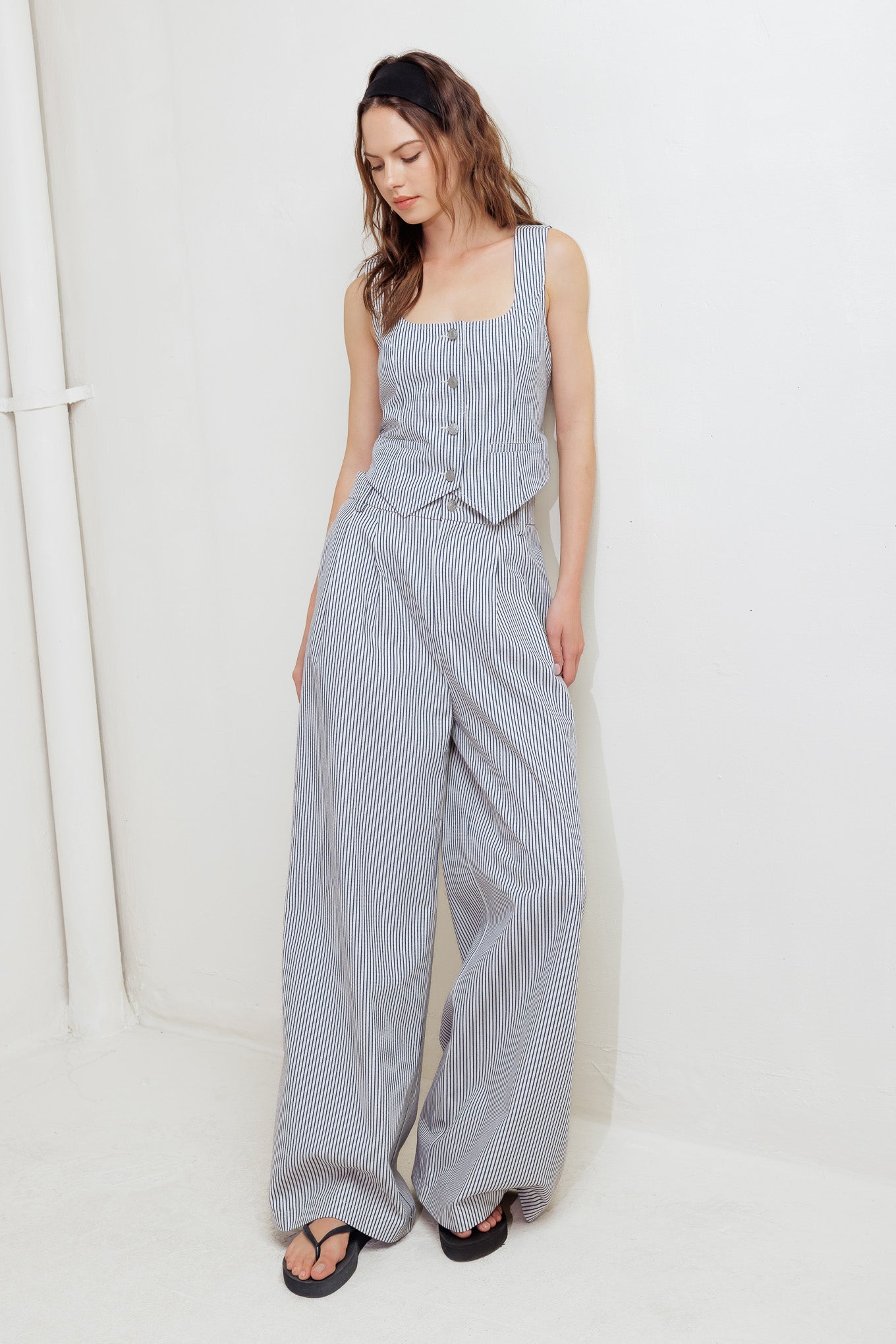 A striped woven vest featuring U neckline, sleeveless and front button down.