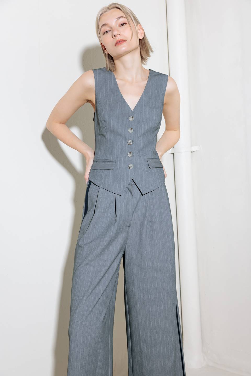 A grey striped woven vest with front button down.