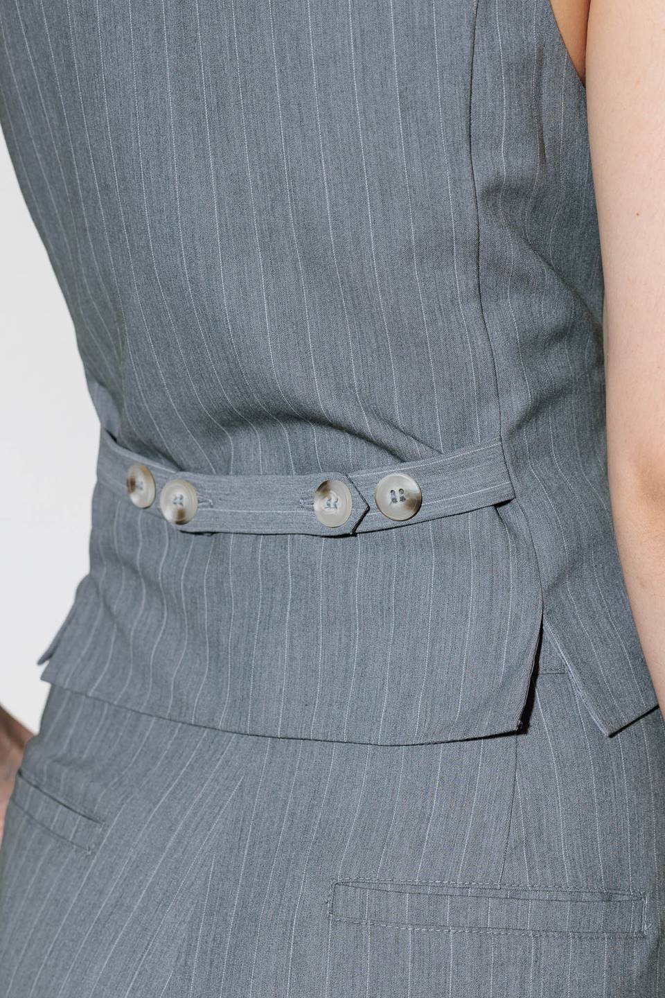 A grey striped woven vest with front button down.