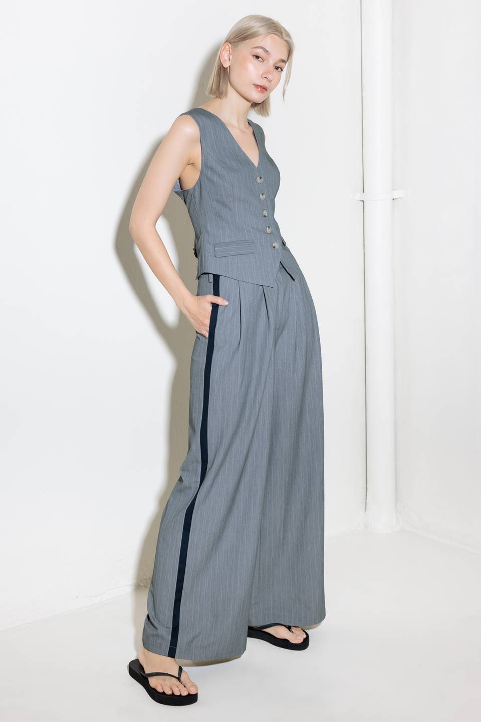 A grey striped woven vest with front button down.