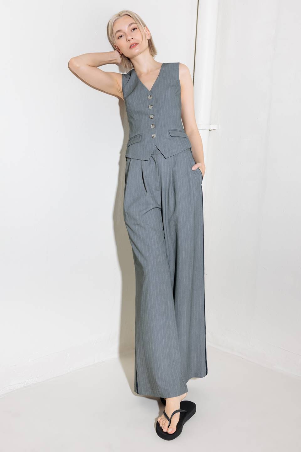 A grey striped woven vest with front button down.