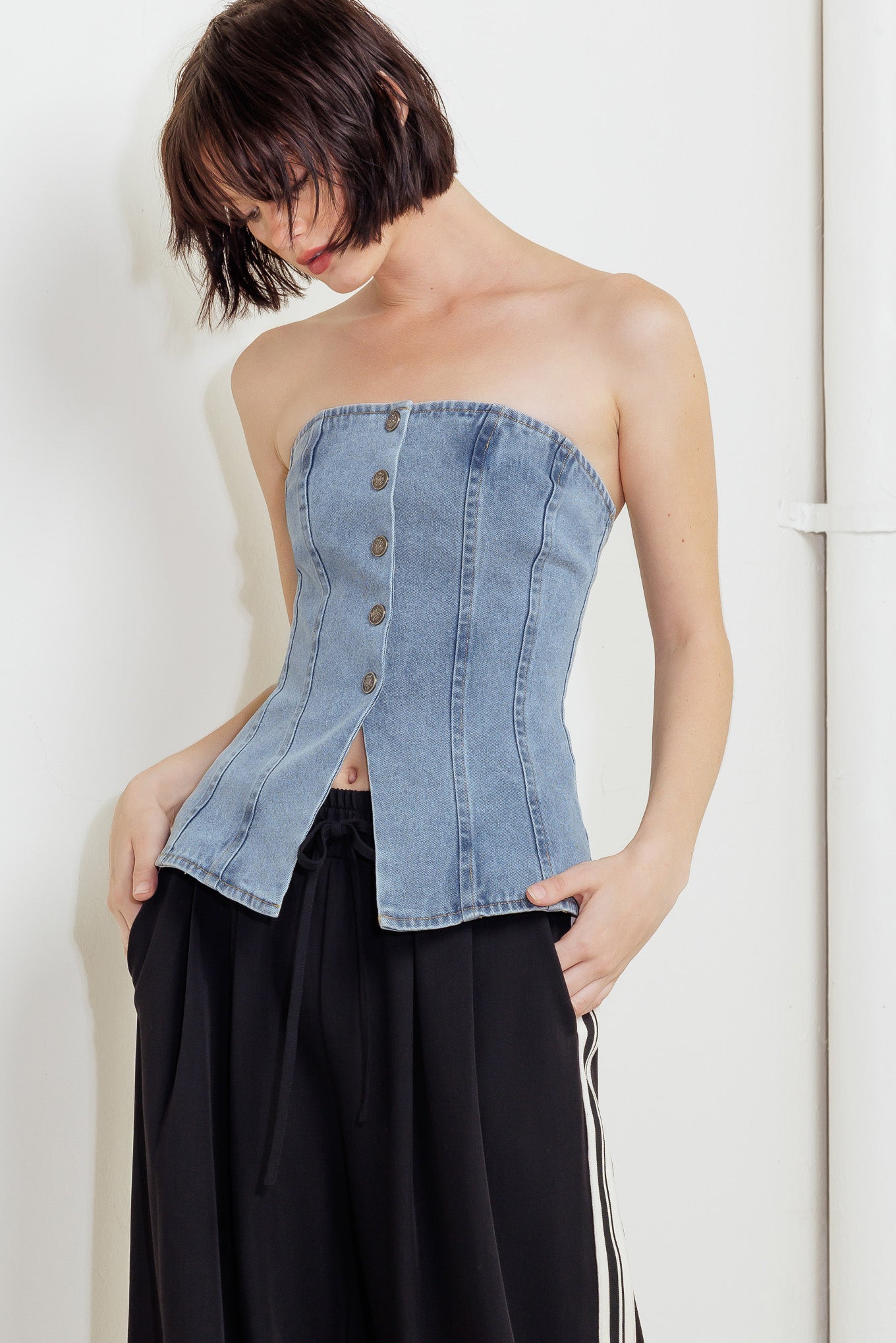 A strapless, washed denim top featuring a front button down
