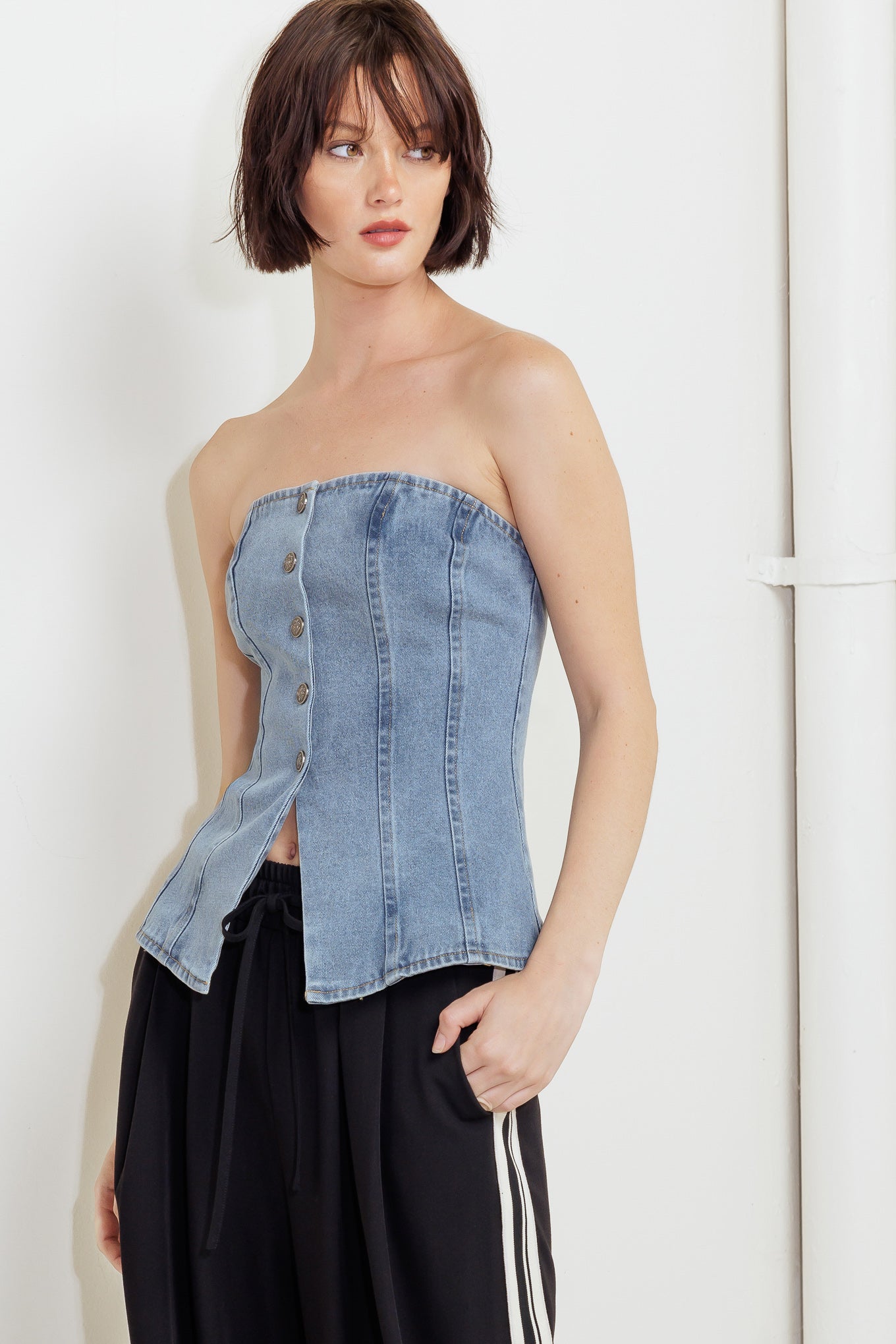 A strapless, washed denim top featuring a front button down