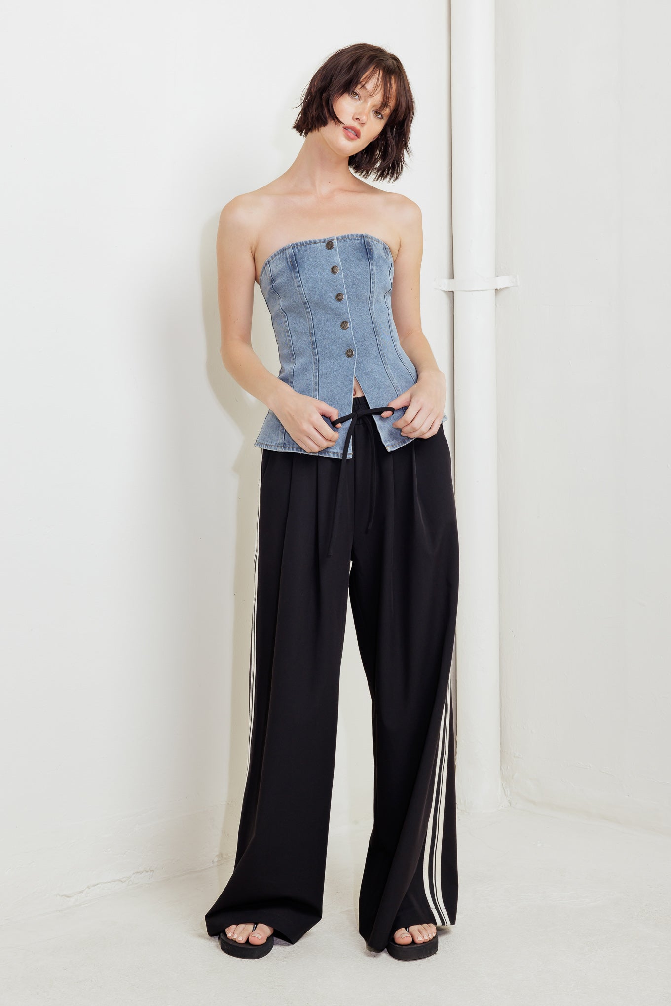A strapless, washed denim top featuring a front button down