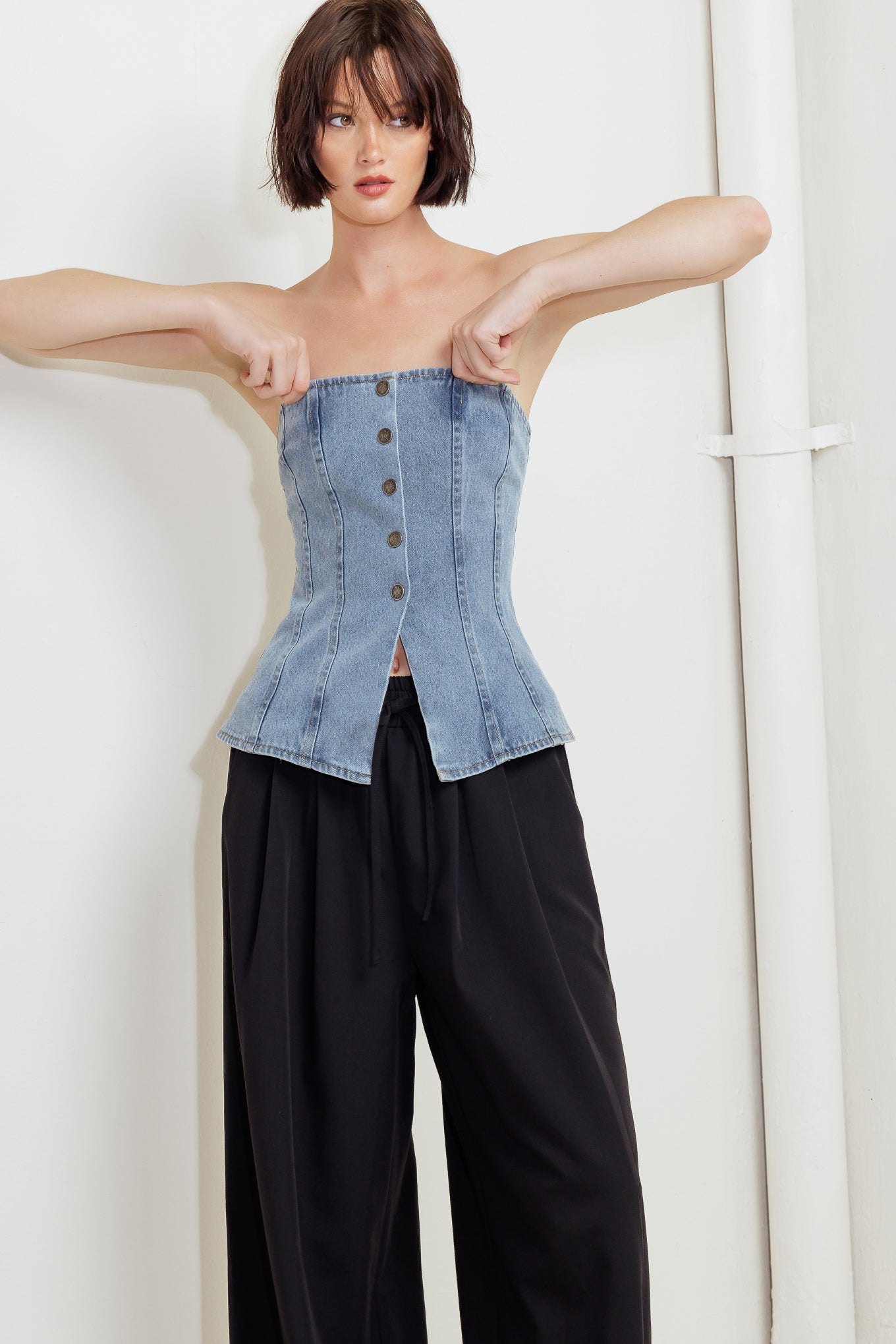 A strapless, washed denim top featuring a front button down