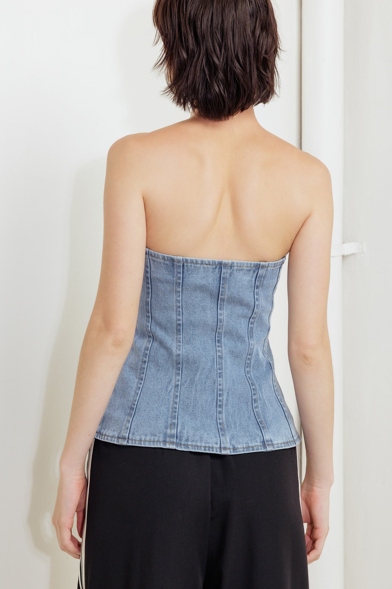 A strapless, washed denim top featuring a front button down