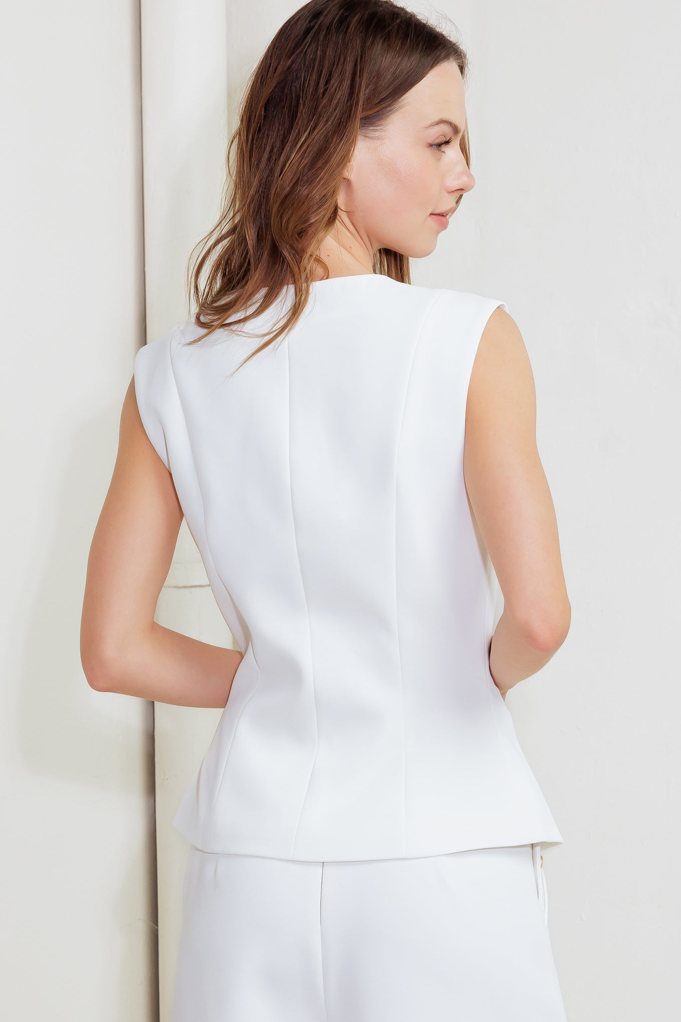 A solid woven vest featuring round neckline, sleeveless and button down closure.