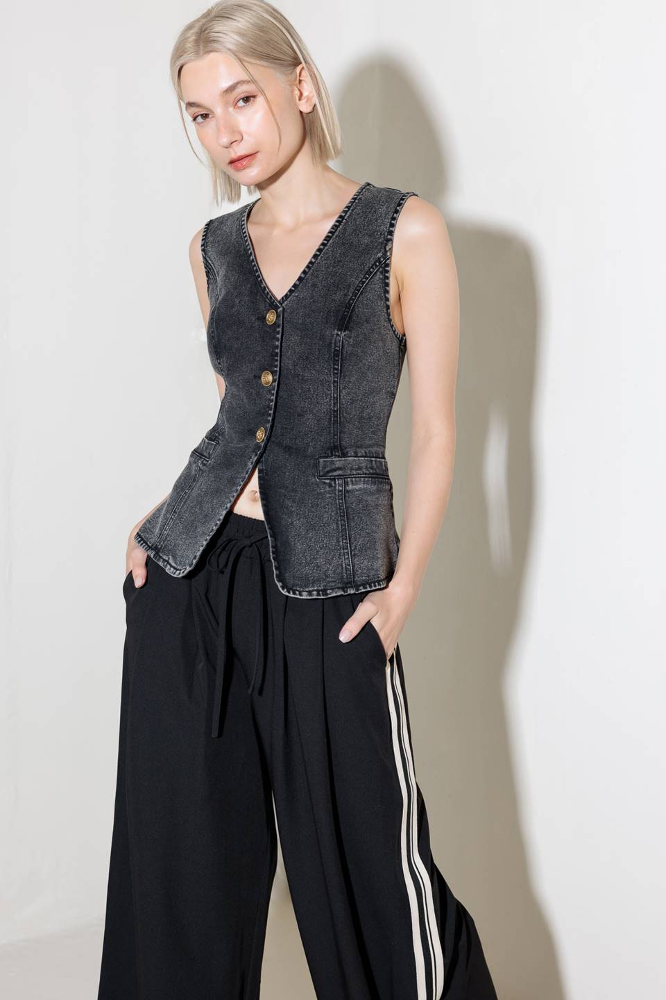 A washed denim vest with V neckline and front closure.
