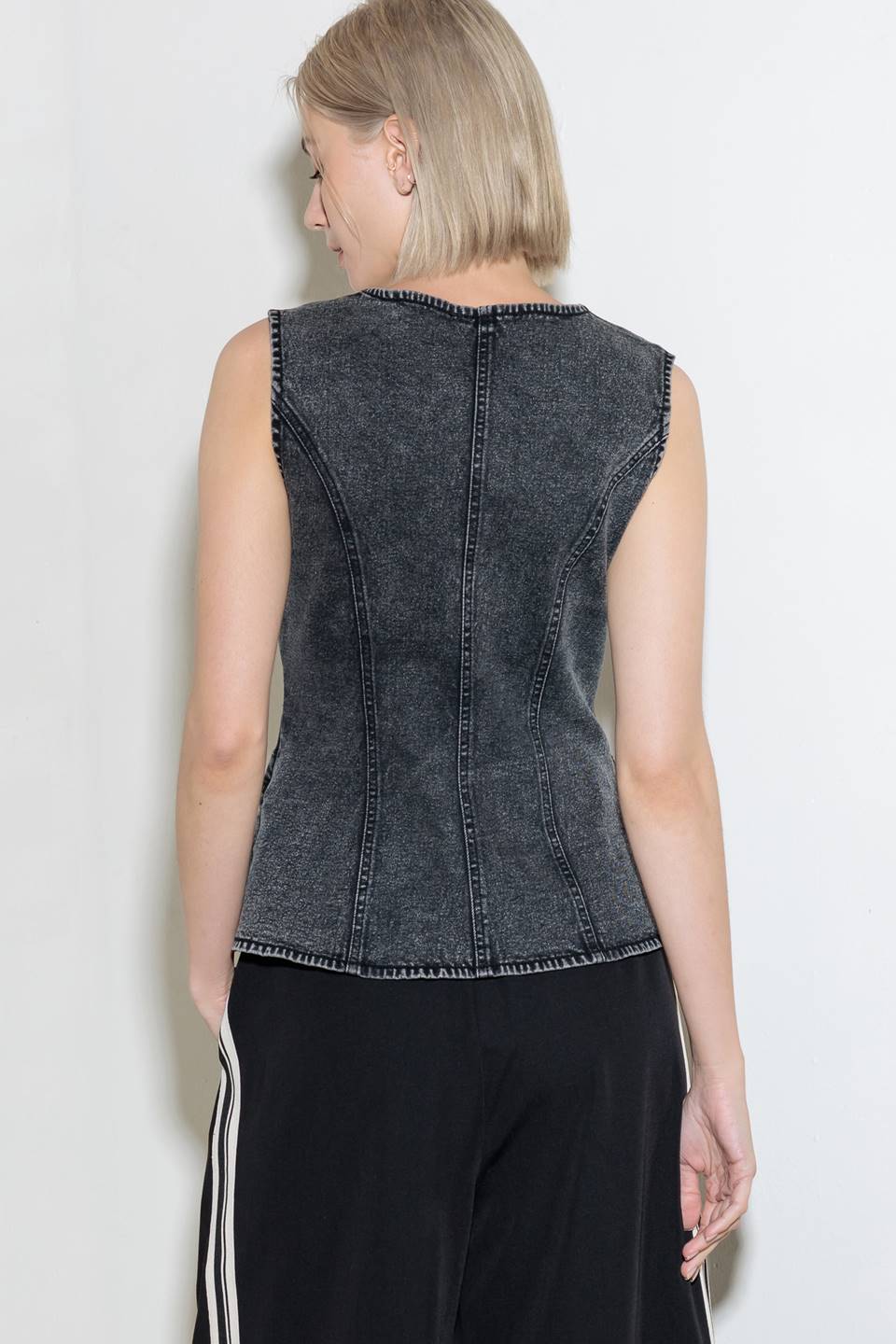 A washed denim vest with V neckline and front closure.