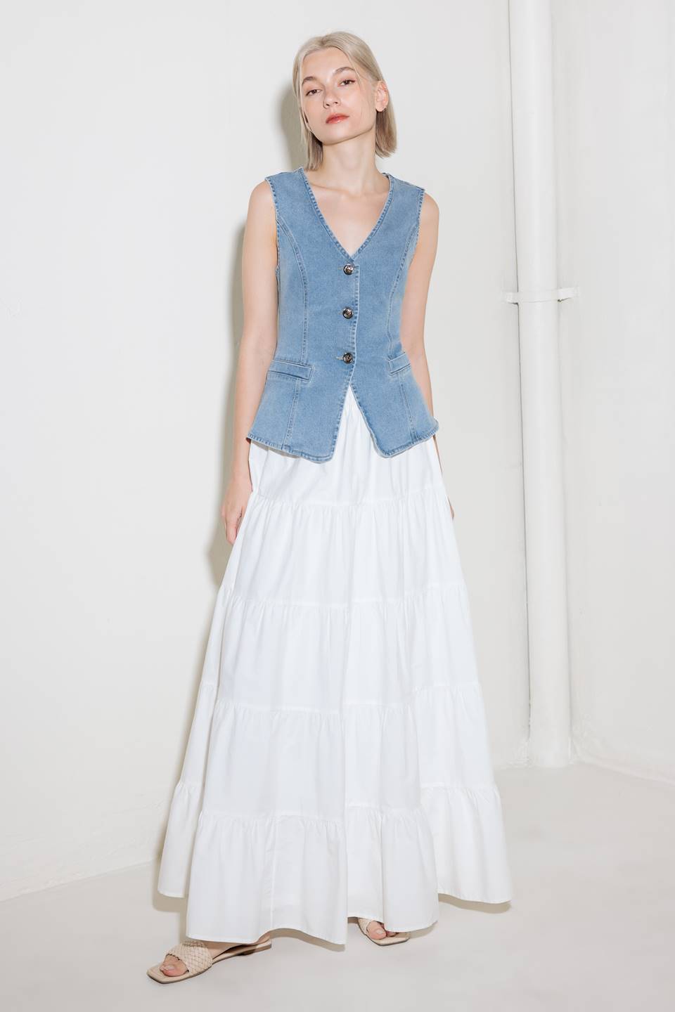 A washed denim vest with V neckline and front closure.