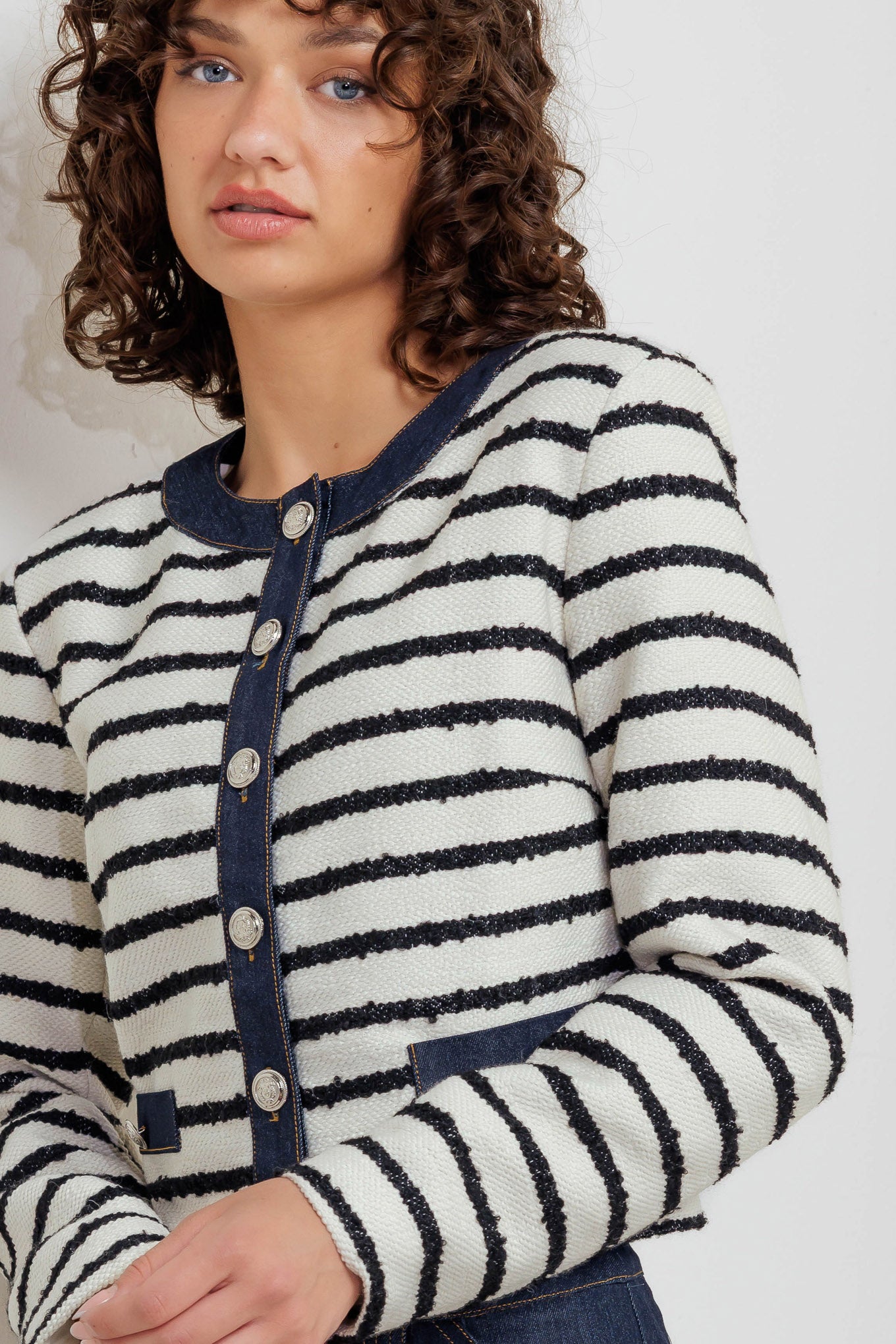 A textured striped woven crop jacket featuring round neckline, long sleeve and front button down.