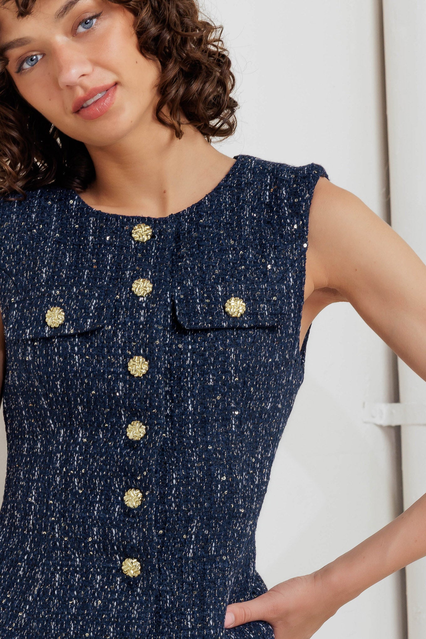 A woven tweed vest featuring round neckline, sleeveless and front button down closure