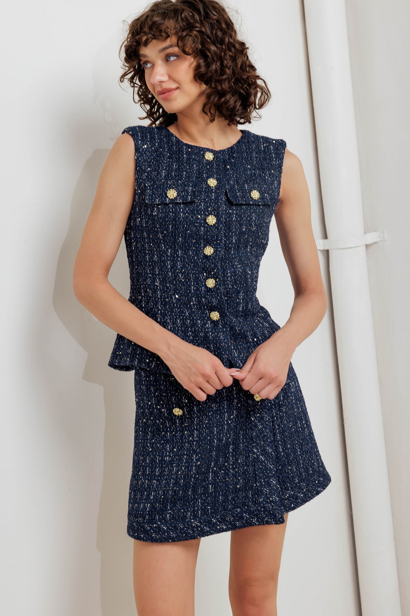 A woven tweed vest featuring round neckline, sleeveless and front button down closure