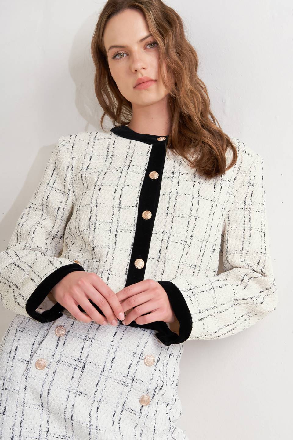 A woven tweed crop jacket featuring round neckline, long sleeve, contrasting hem and front button closure