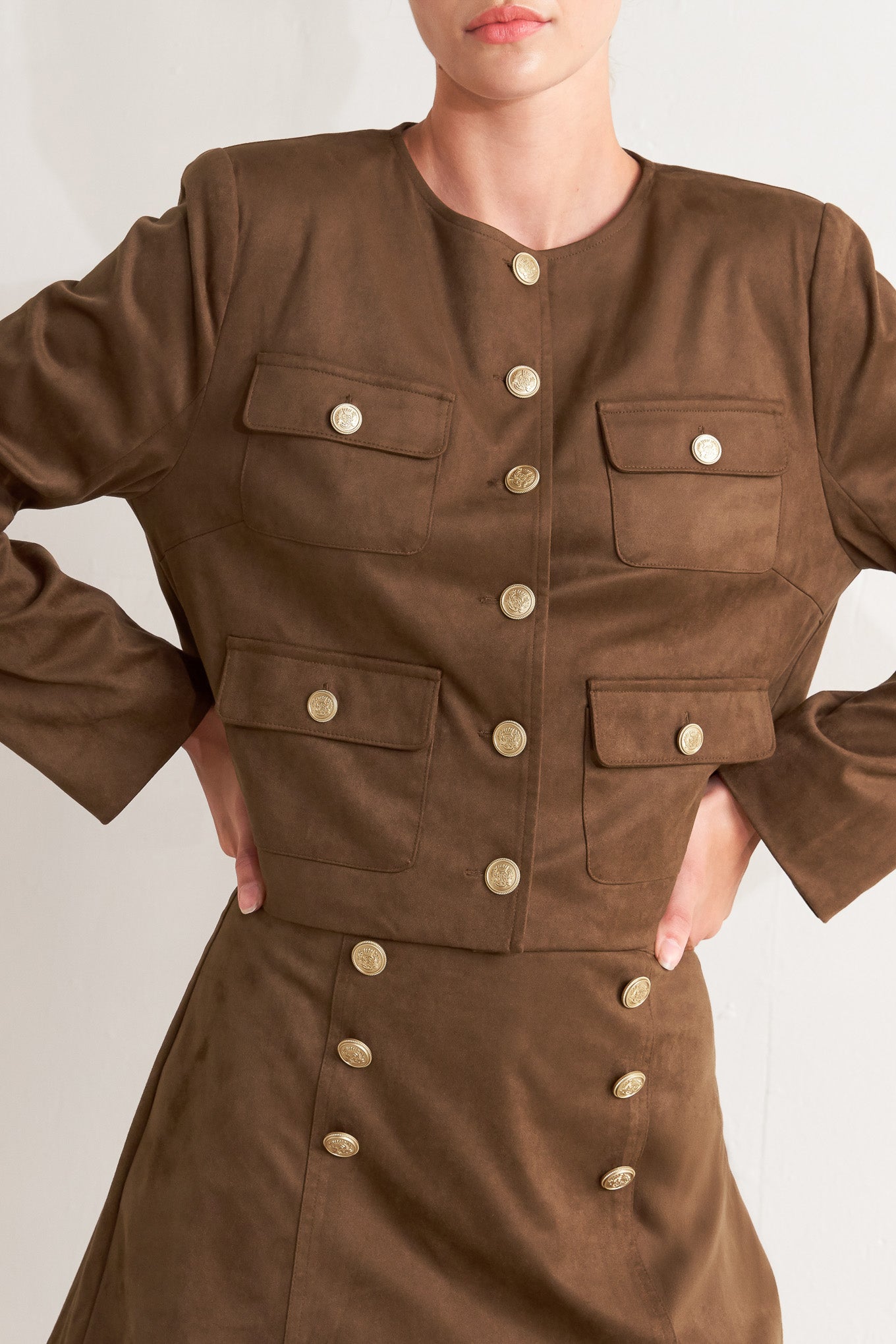 A faux suede cropped jacket featuring round neckline, long sleeve, front pockets and button down. 