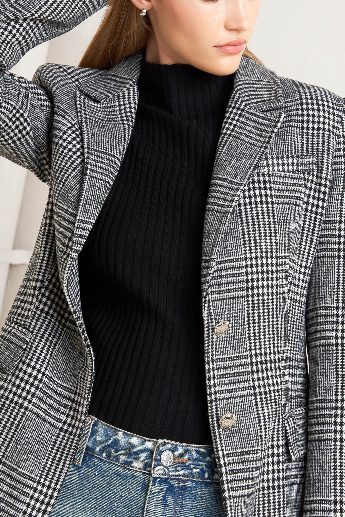 A woolen woven plaid jacket with front closure.