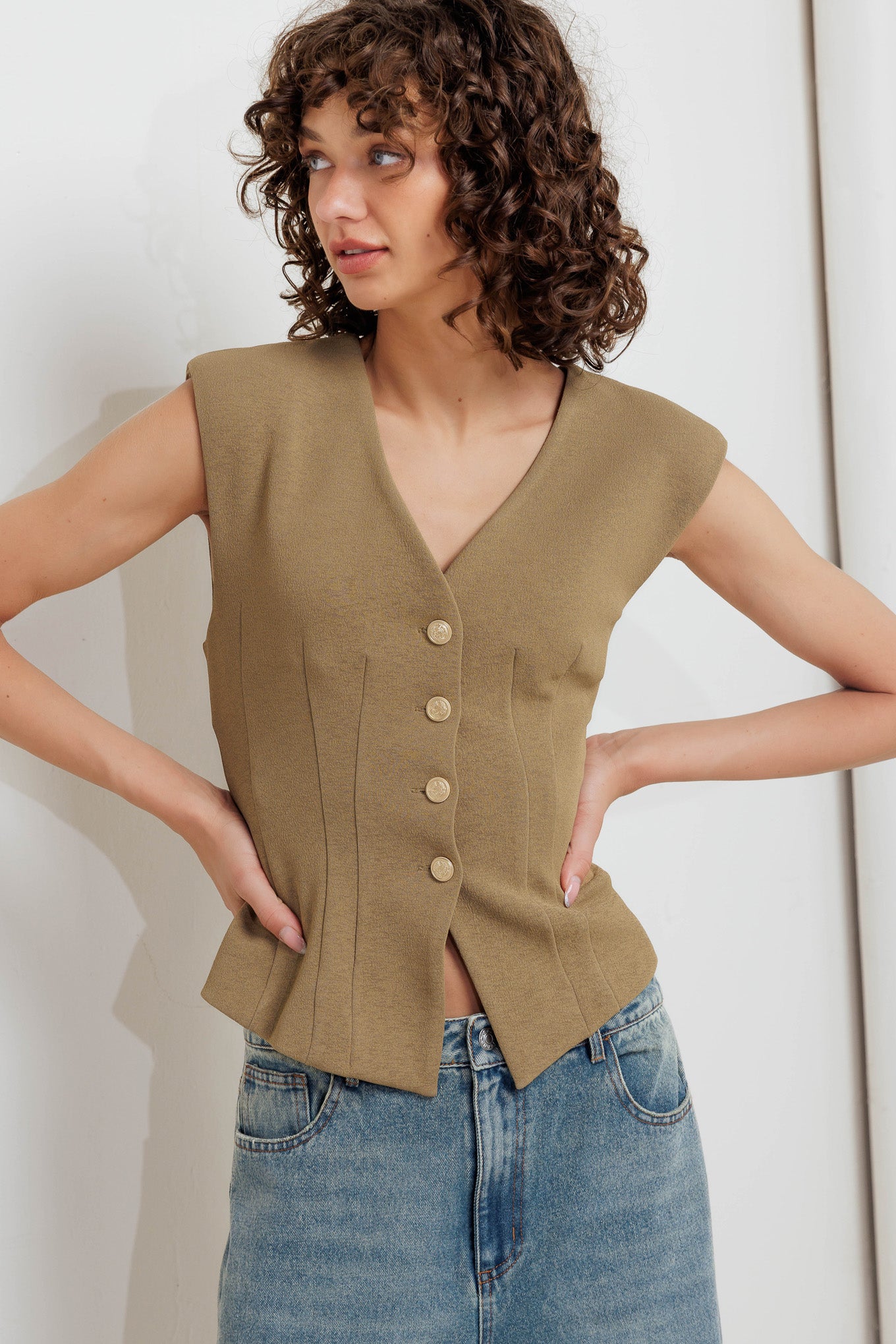 A solid woven vest with V neckline and front button closure