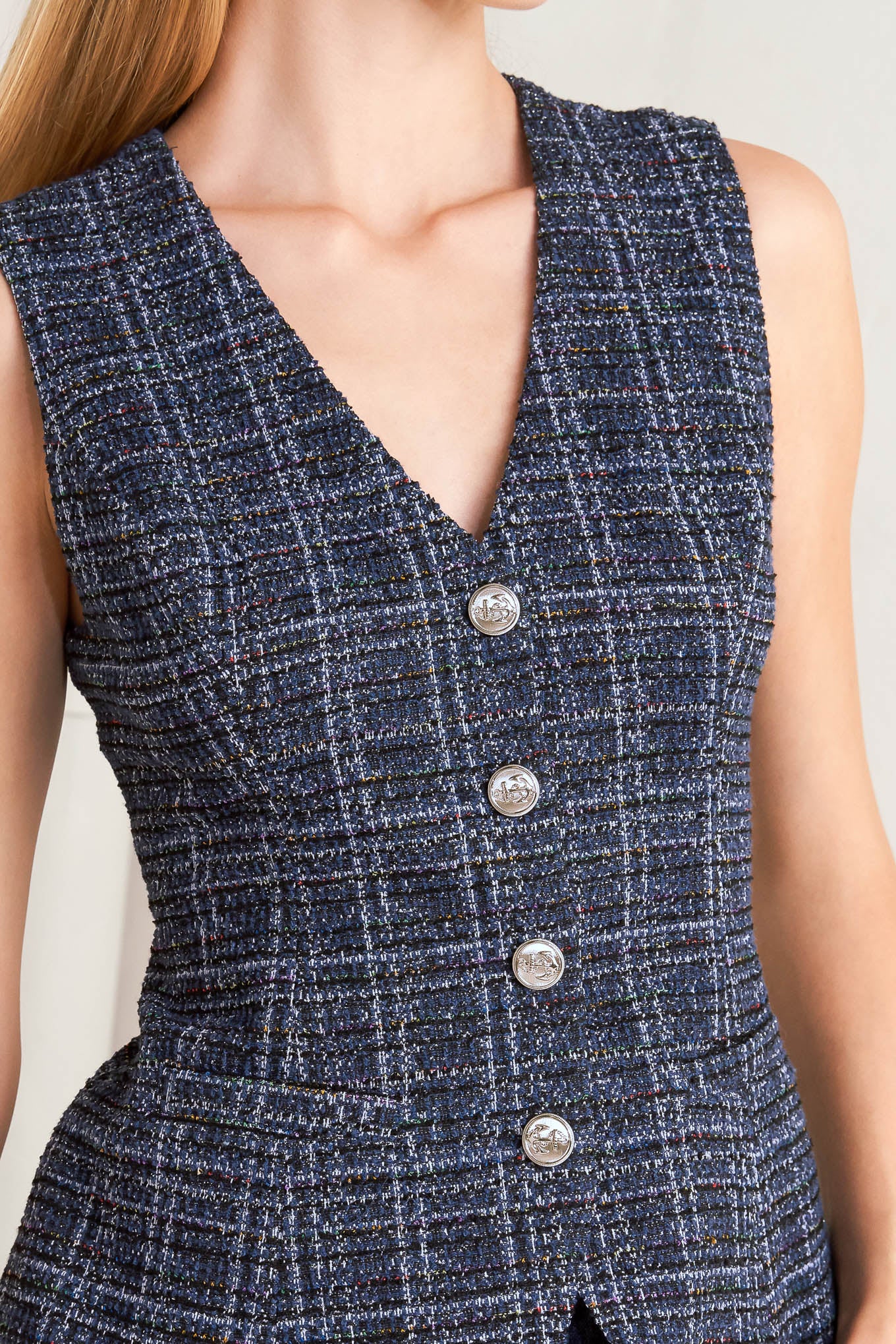 A tweed vest with front button closure