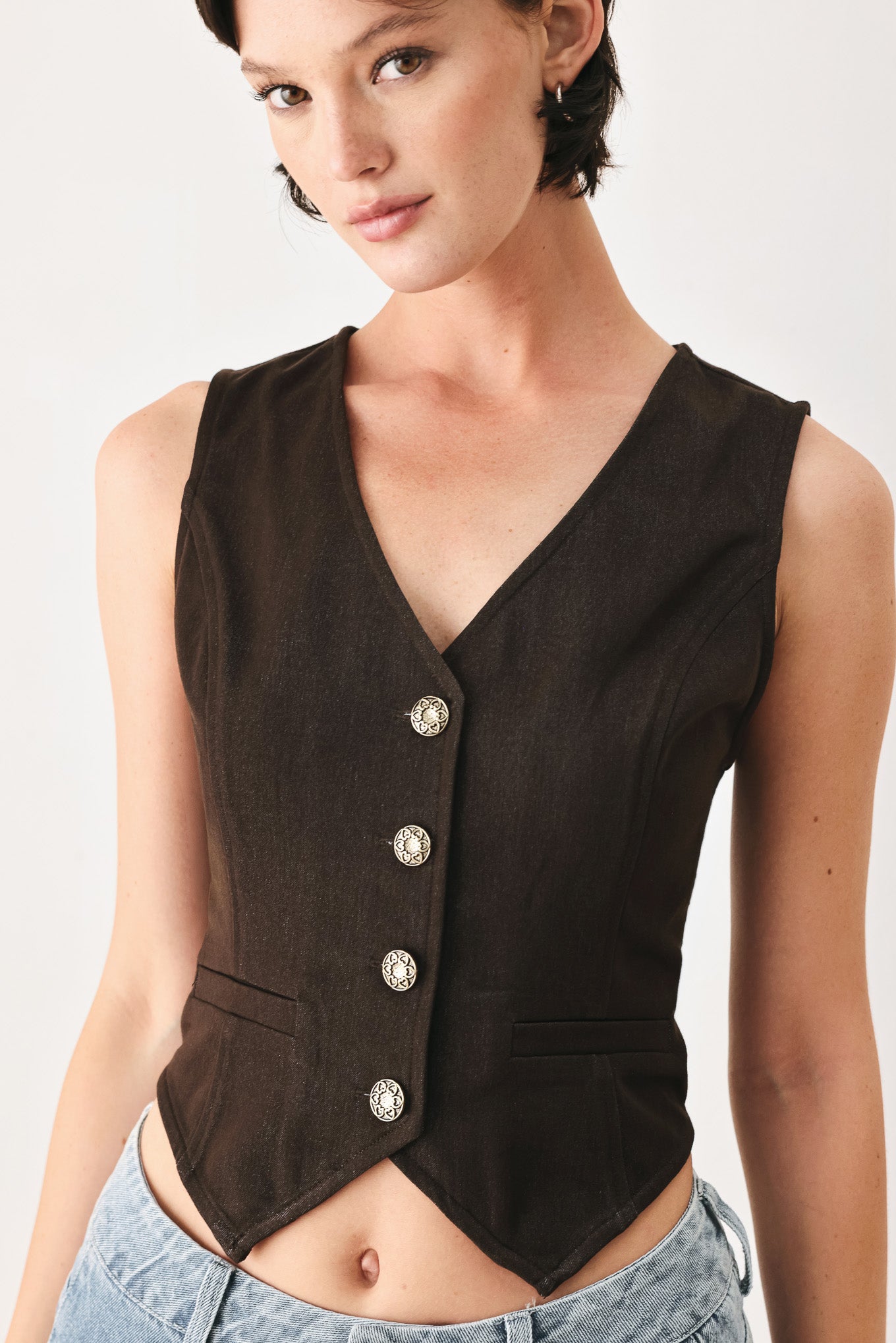 Woman wearing a brown sleeveless vest with buttons | FREEMARKET