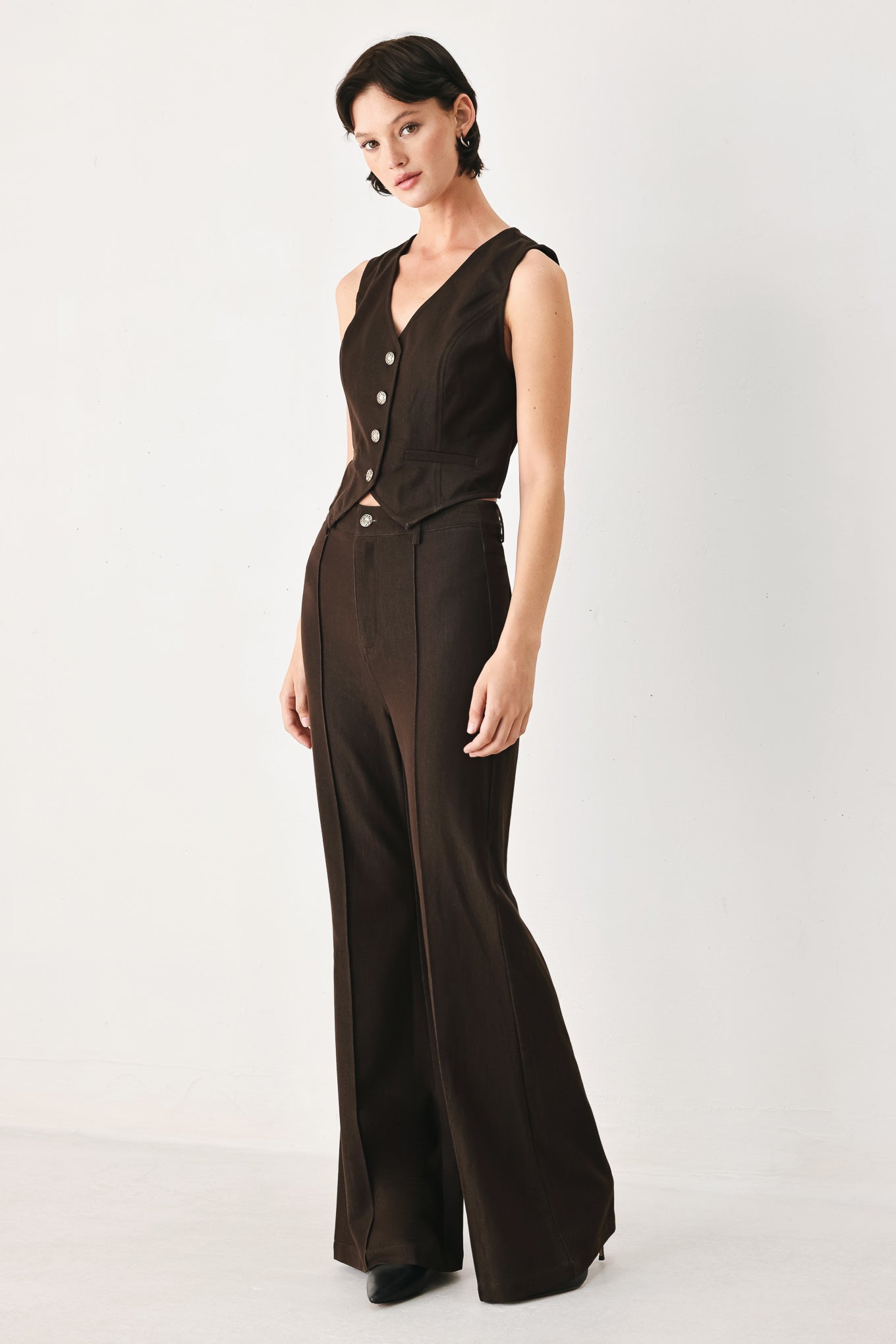 Woman wearing a brown sleeveless vest with buttons | FREEMARKET